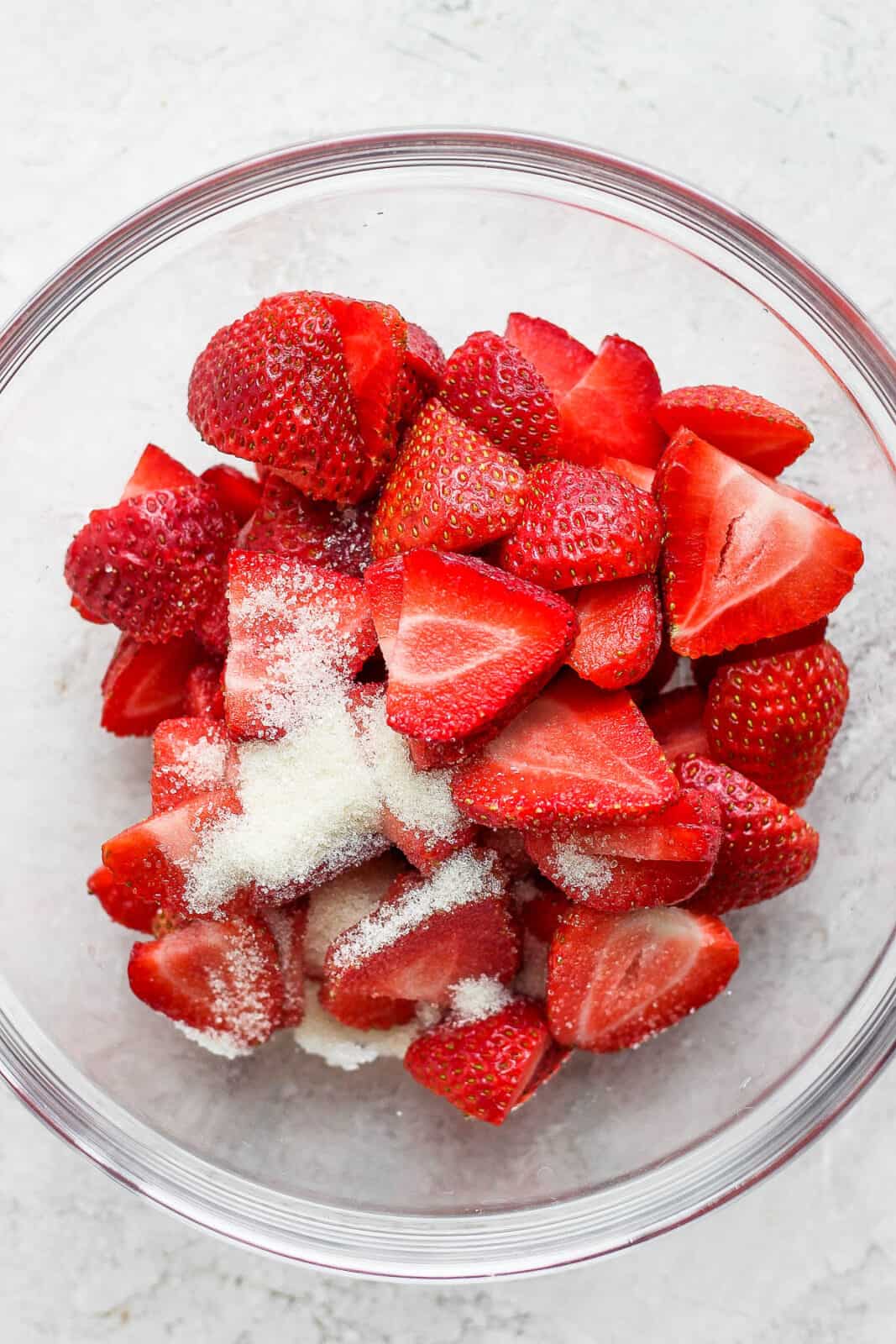Sliced strawberries and coconut sugar in a bowl.