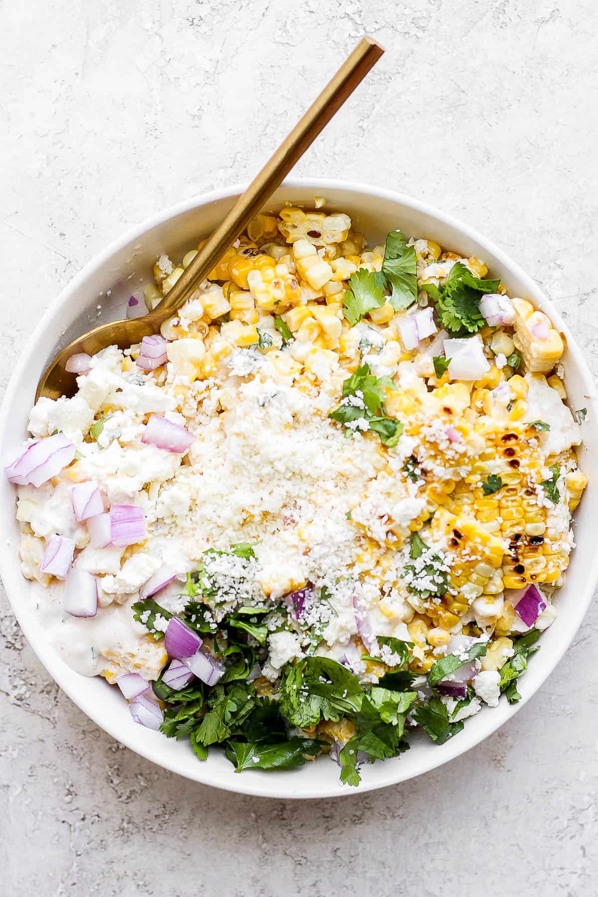 Mexican street corn salad in a bowl with a spoon.