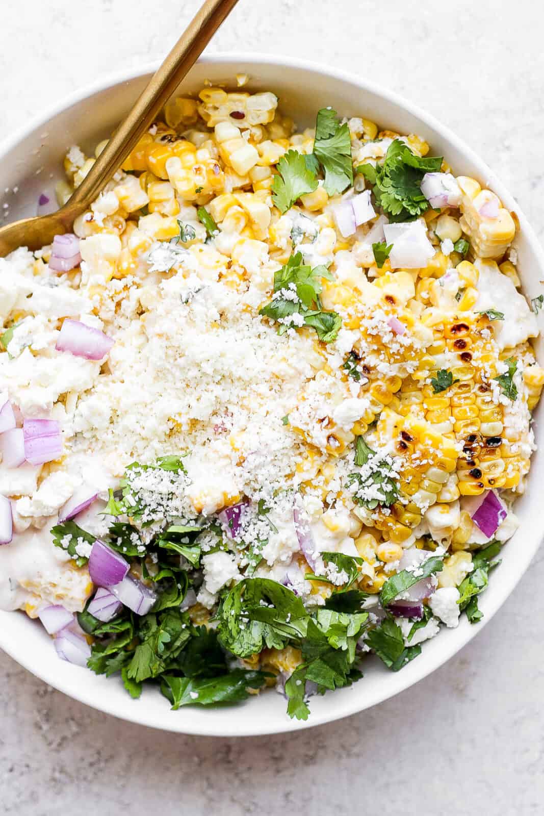 Mexican street corn salad in a bowl with spoons.