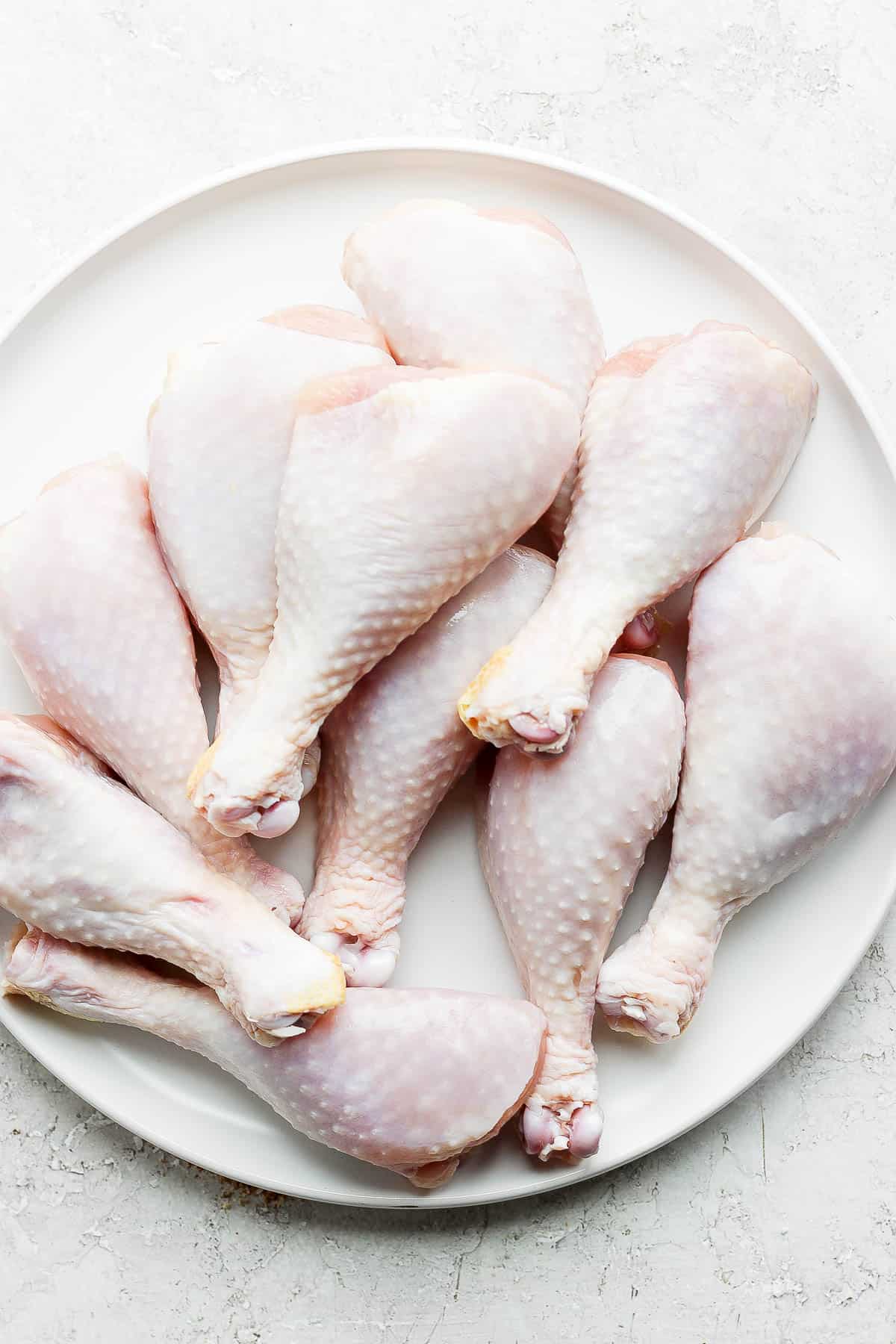 A plate of raw chicken legs.