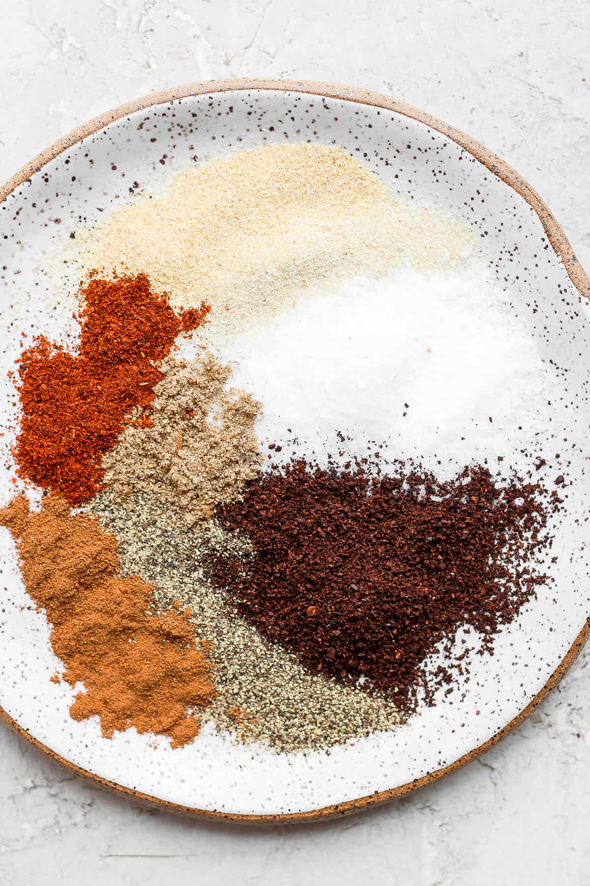 A plate with ingredients for steak dry rub.