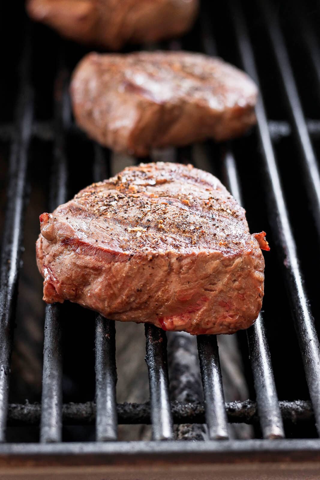 Three steaks on the grill. 