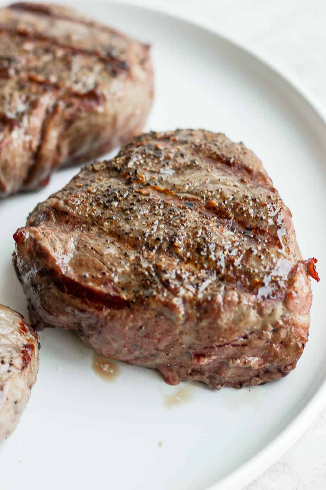 Three grilled steaks on a plate. 