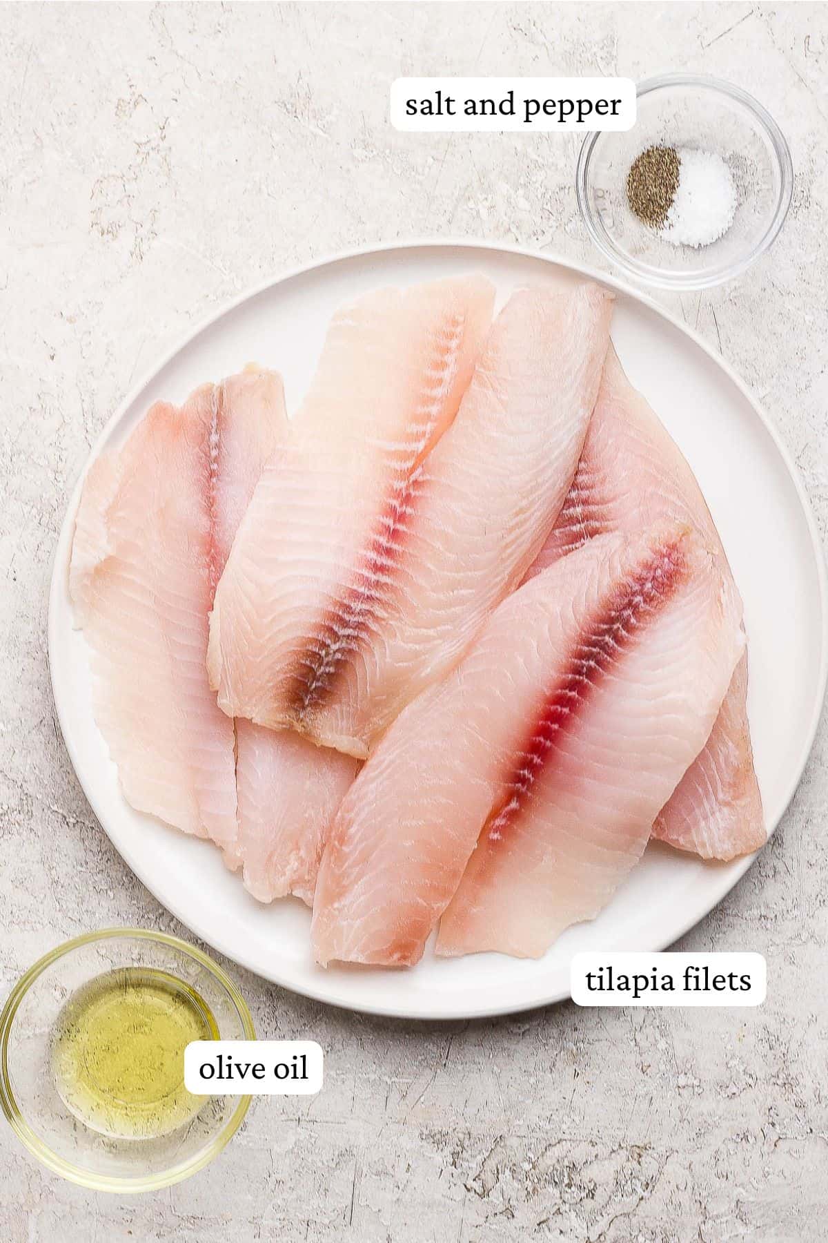 Ingredients for oven baked tilapia labeled and separated out on plates and in bowls.