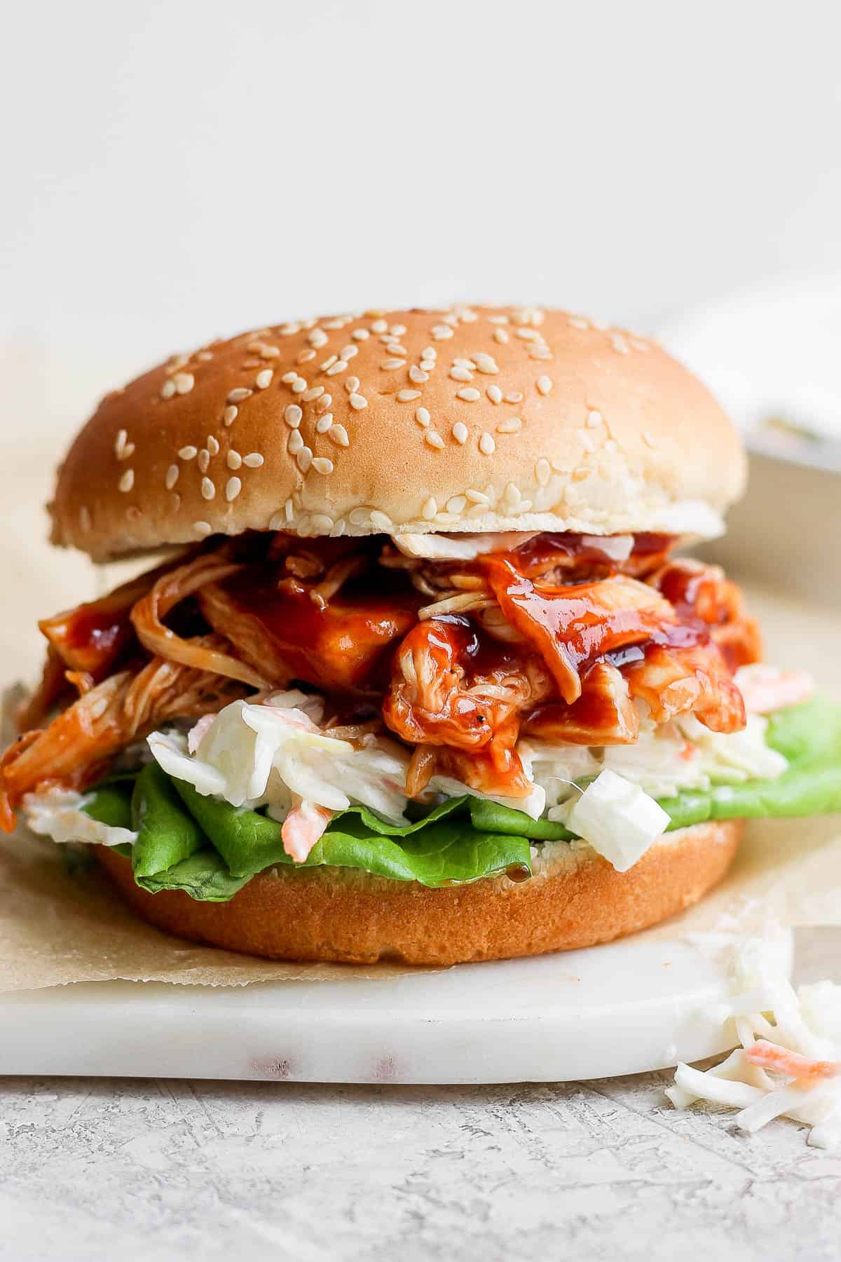 Instant pot bbq chicken as a sandwich on a plate.