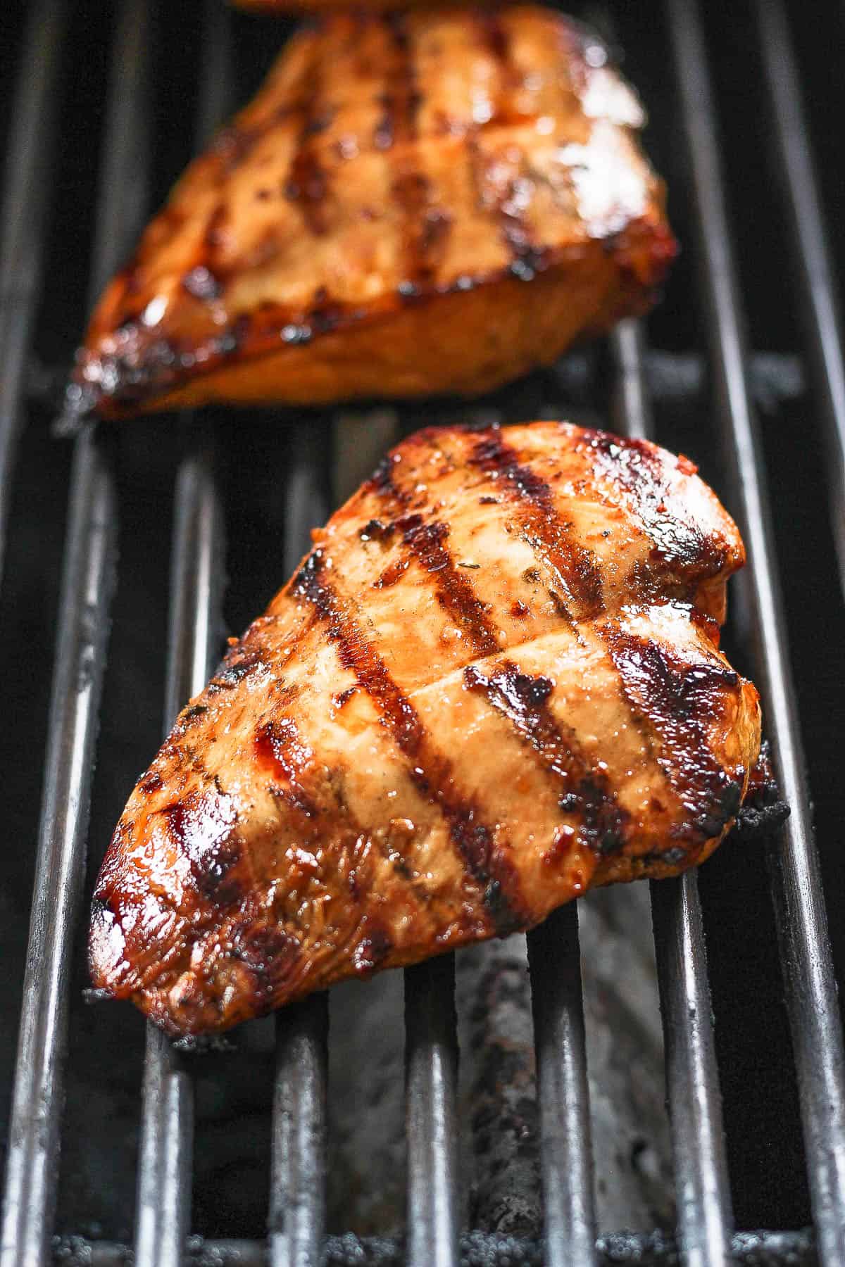 Marinated chicken breasts cooking on the grill.