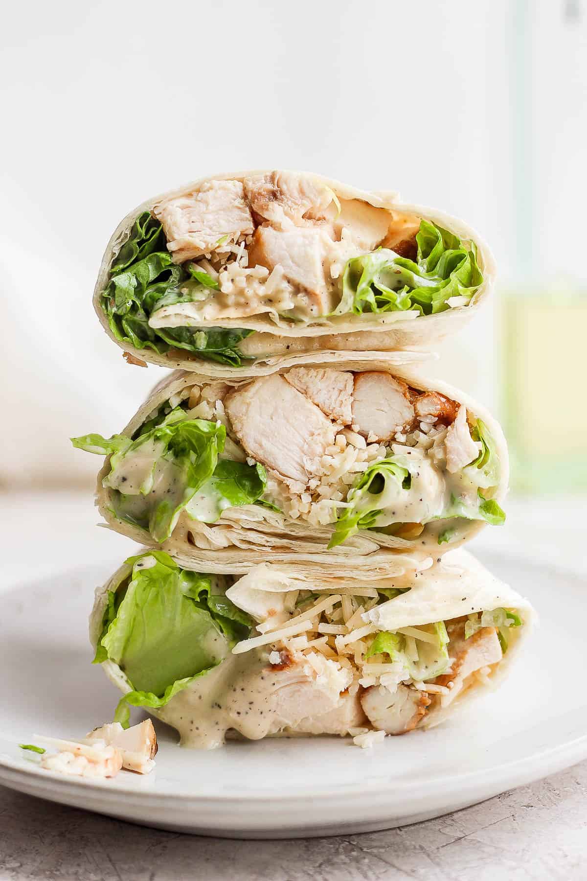 Three halves of chicken caesar wraps on top of each other.