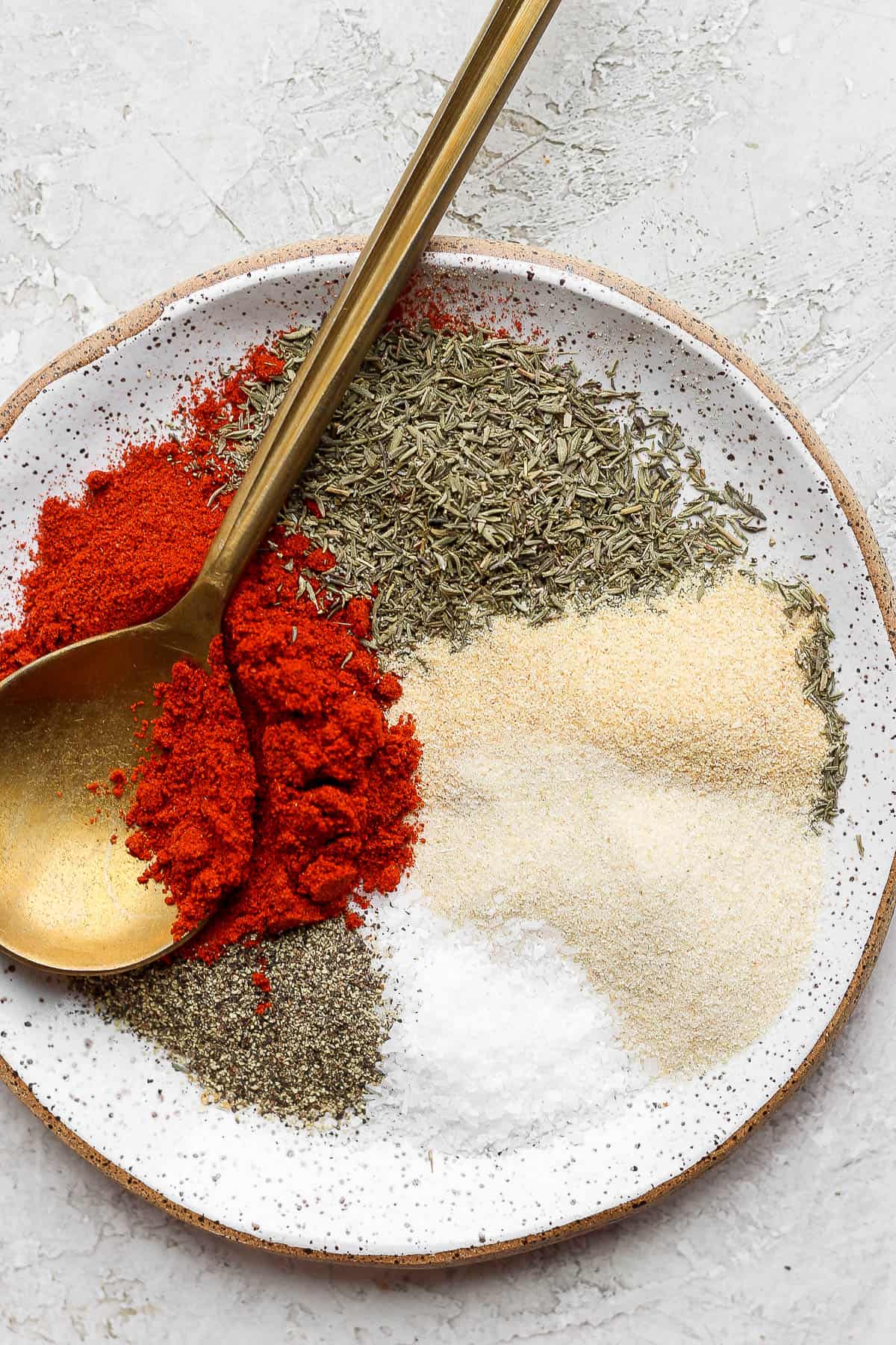 Chicken seasoning ingredients measured out on a plate.