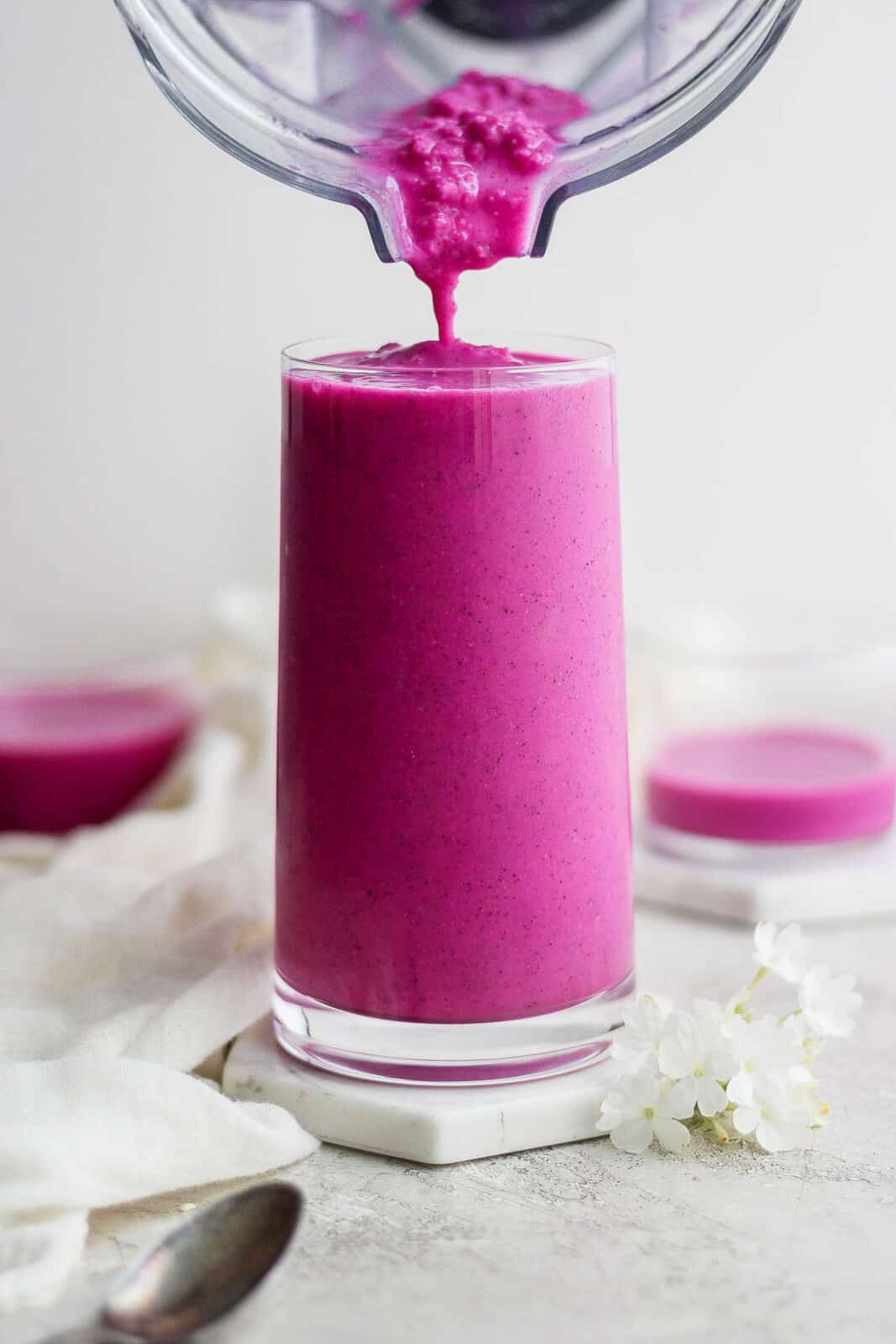 Dragonfruit smoothie being poured into a glass.