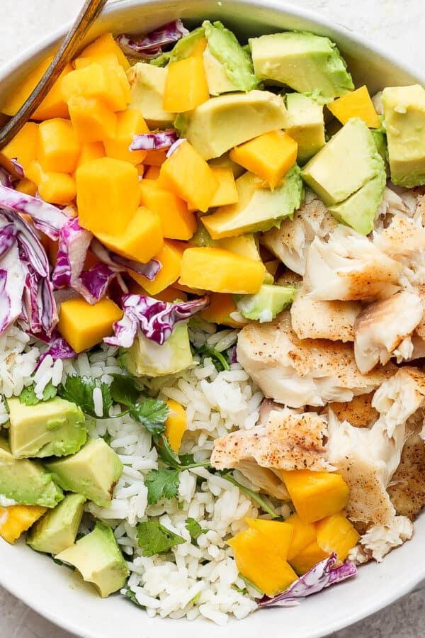 A fully assembled fish taco bowl in a white bowl.