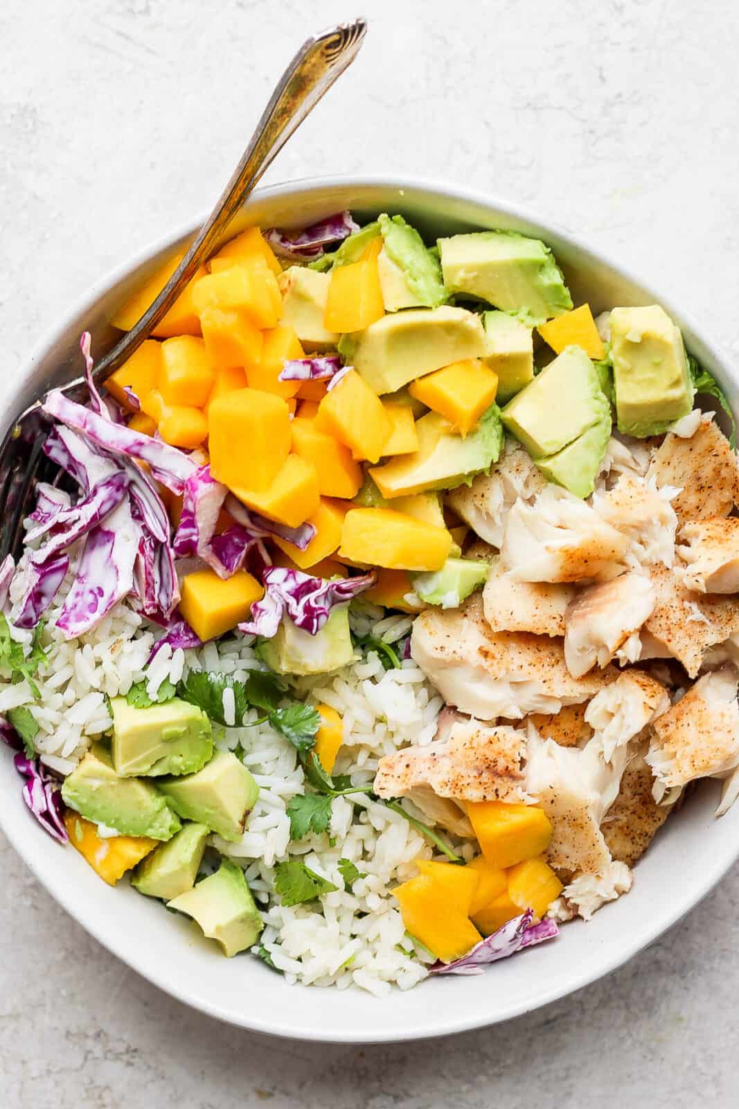 Fish taco bowl with rice and a fork.