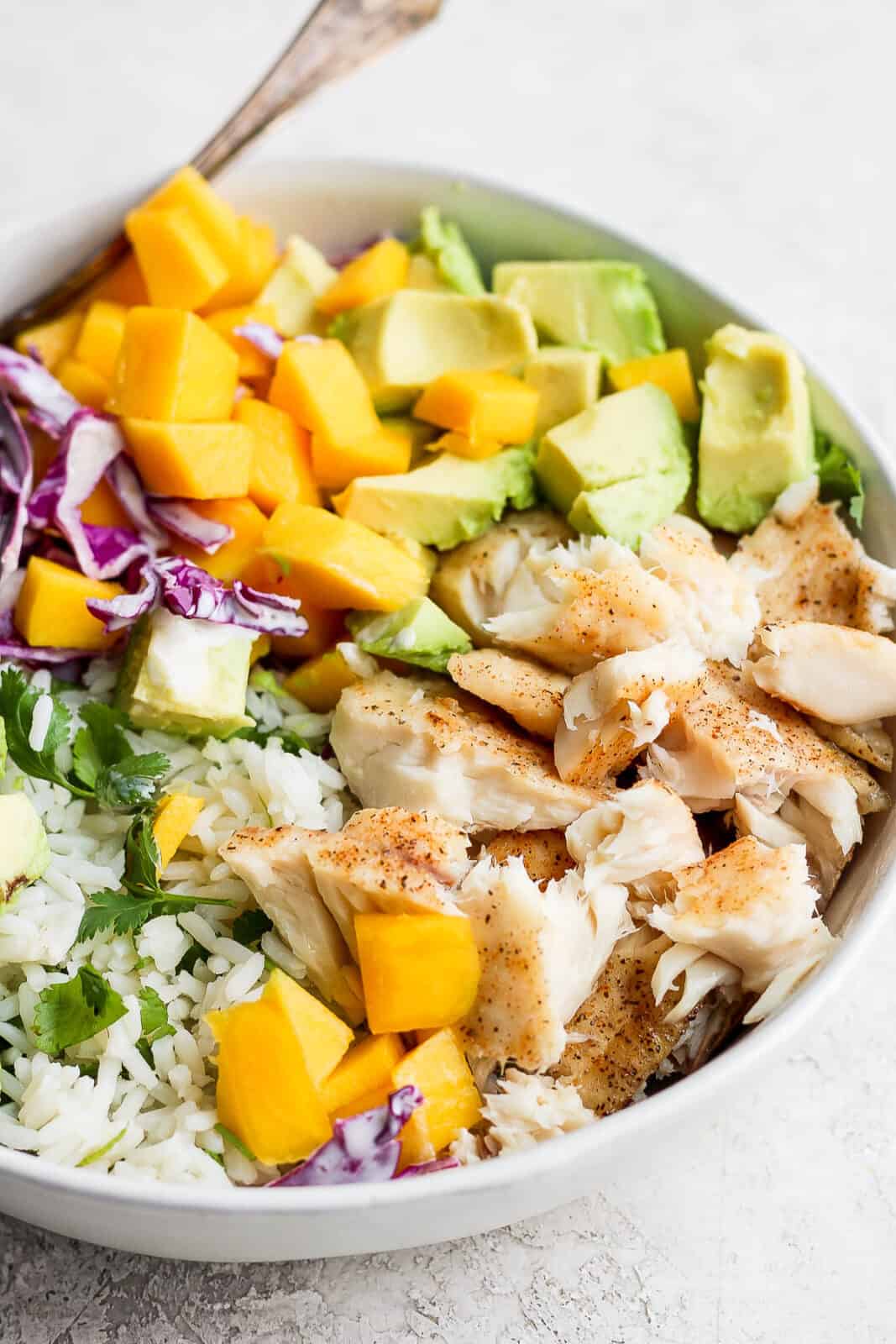 Fish taco bowl with rice and a fork.