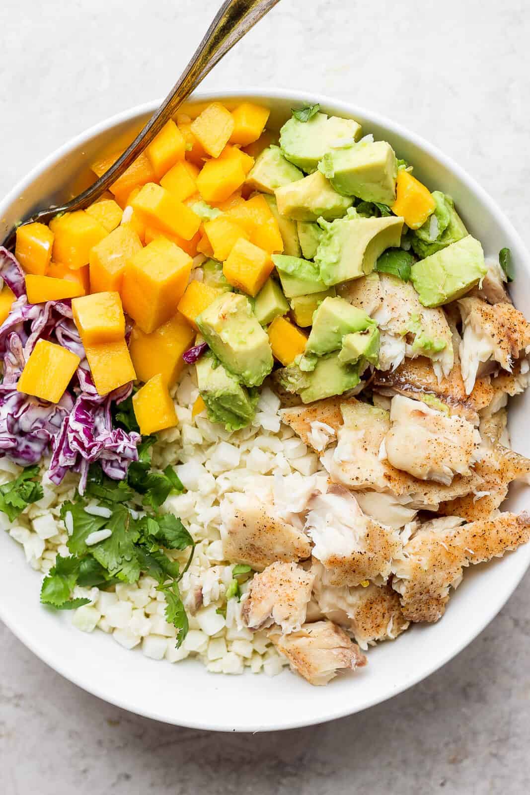 Fish taco bowl with cauliflower rice and a fork.