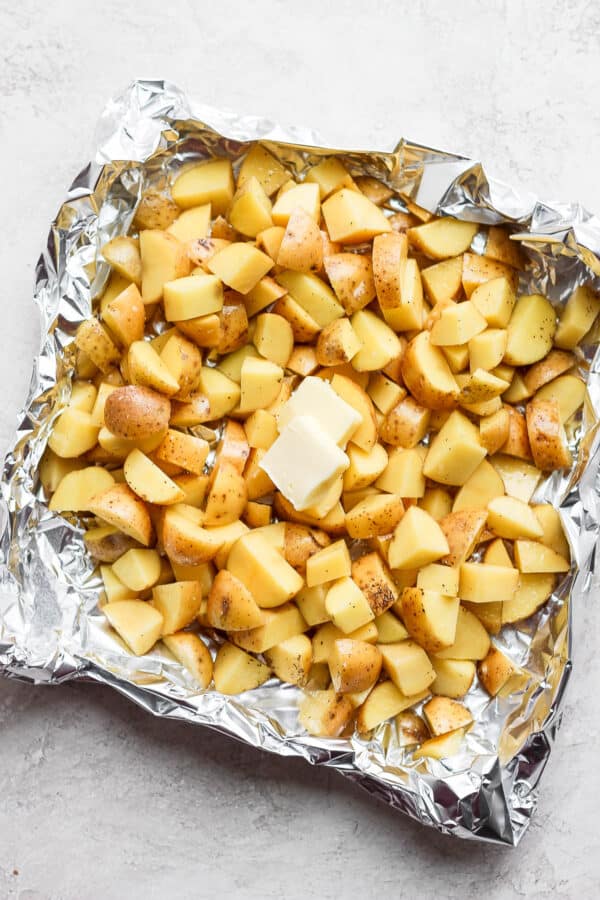 Cut up potatoes in a large piece of aluminum foil with butter on top.