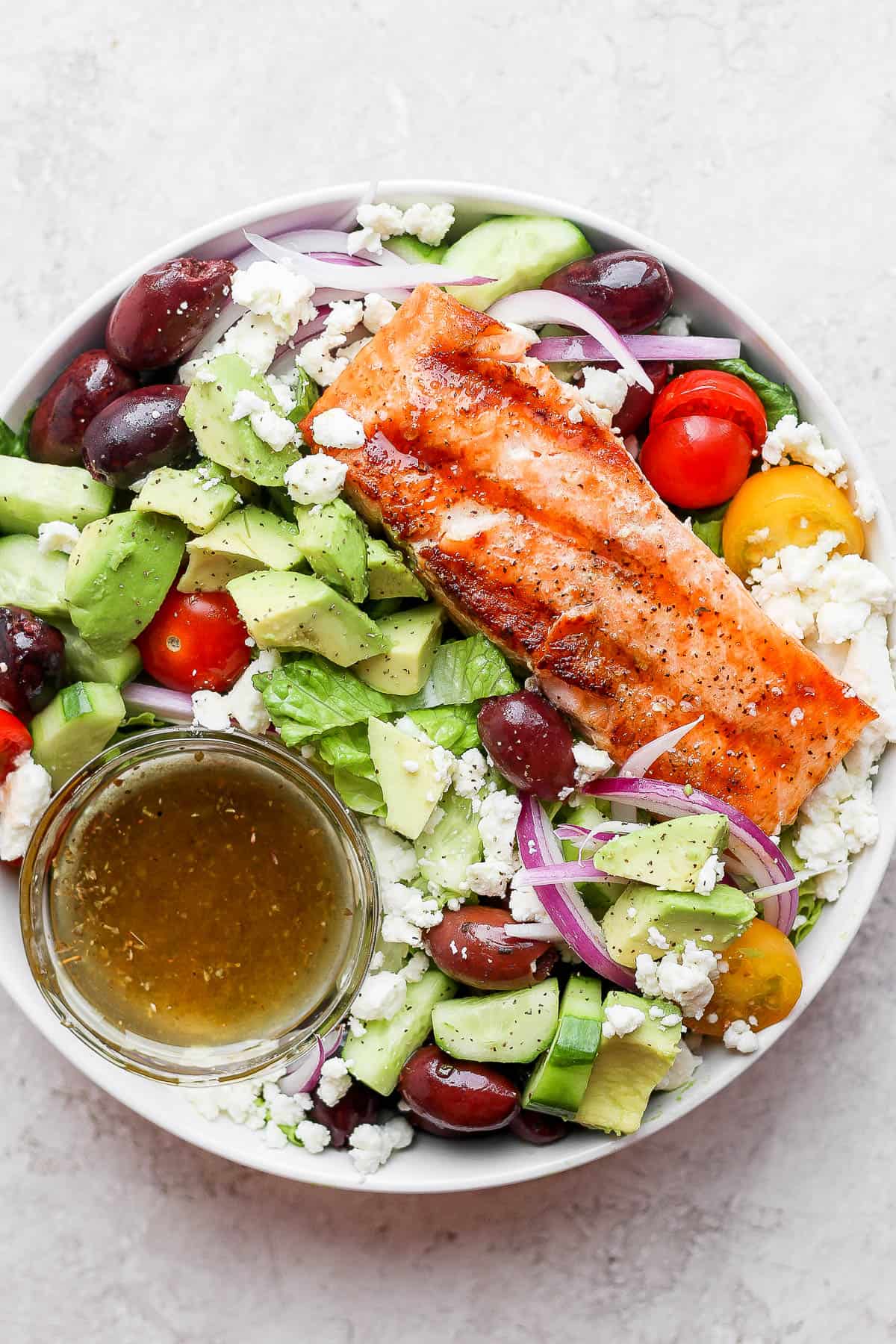 A small dish of greek vinaigrette in a salmon salad.