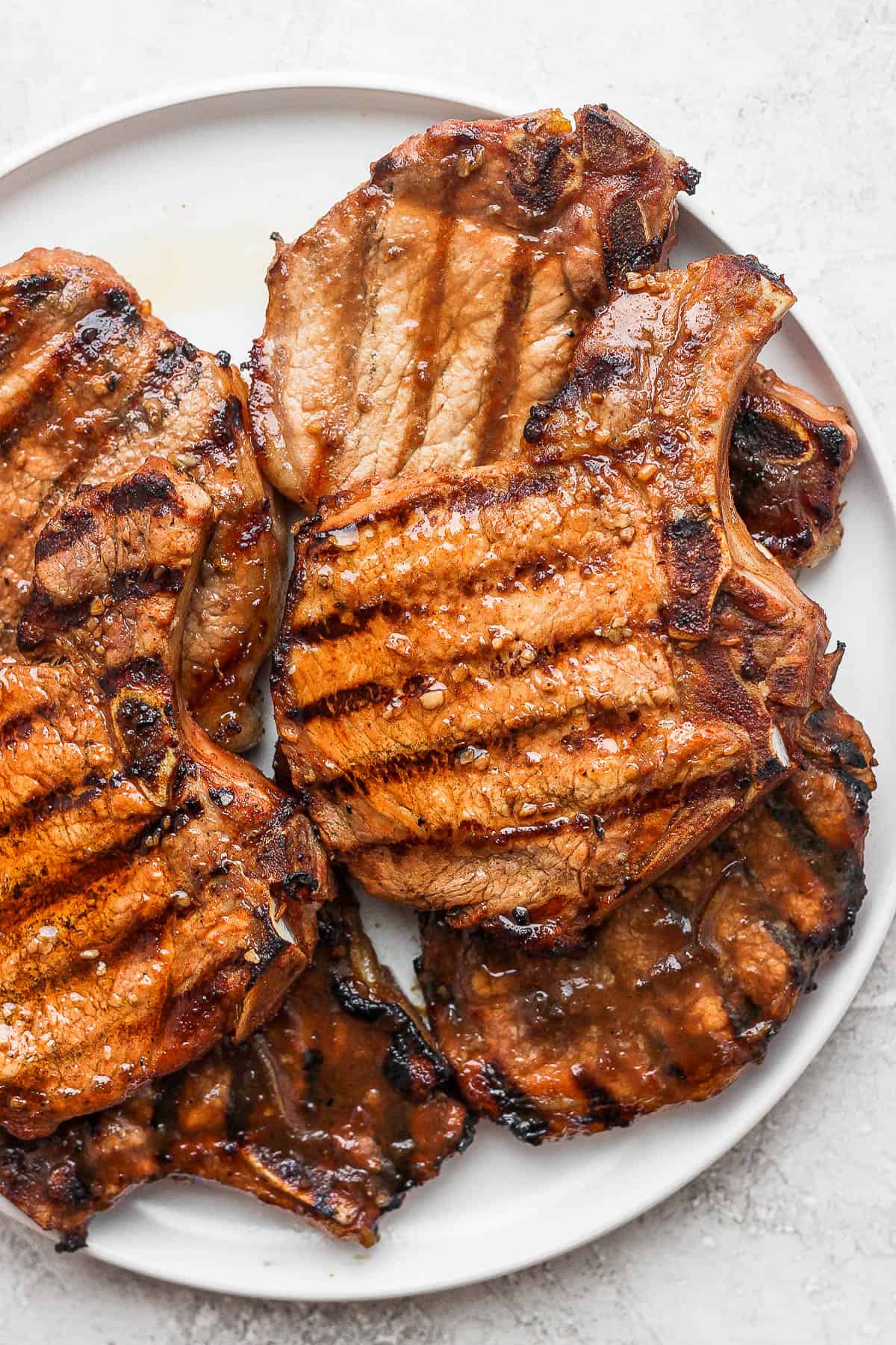 Grilled marinated pork chops on a plate.