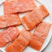 Salmon on a plate with salmon seasoning on top.