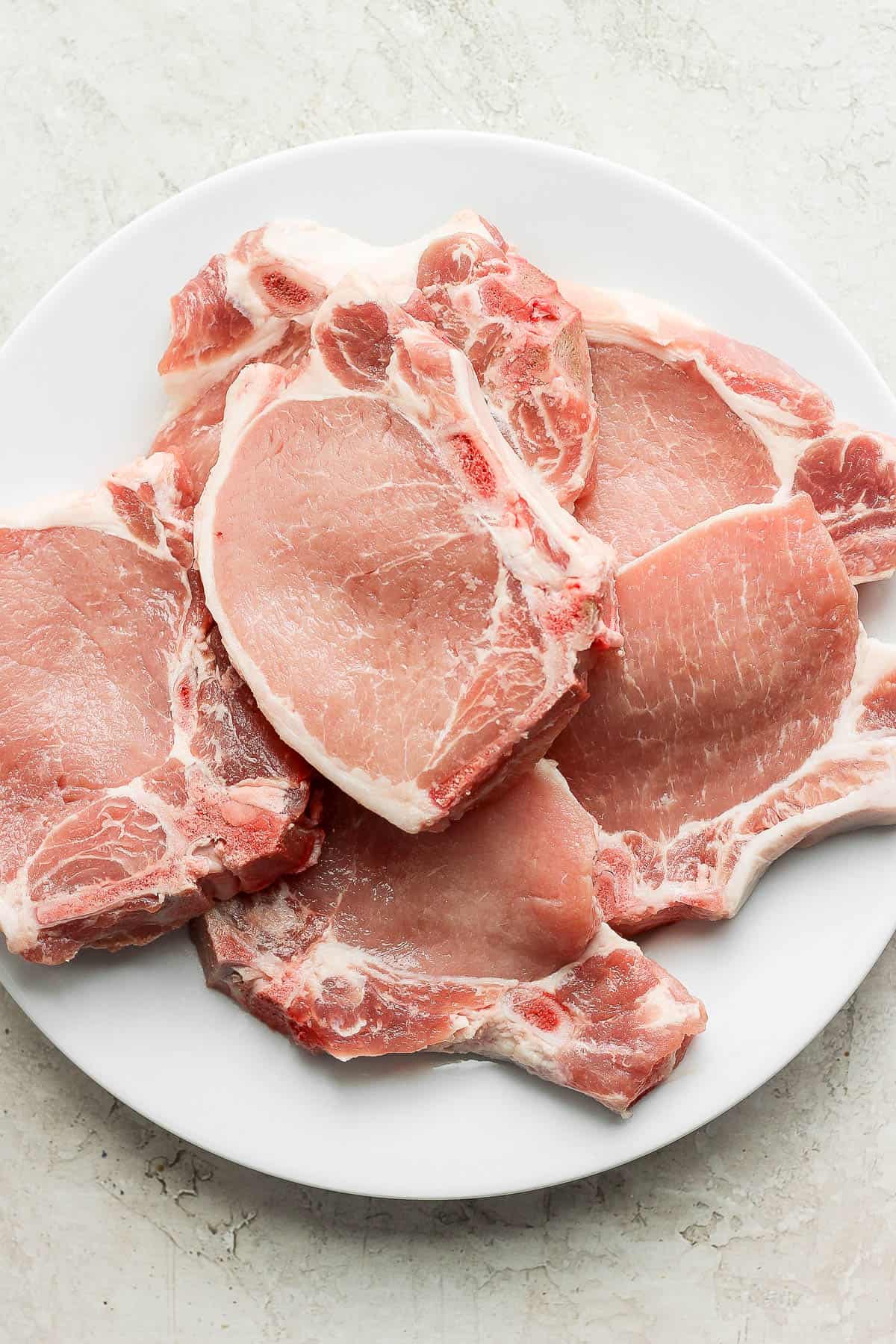 Plate of raw pork chops. 