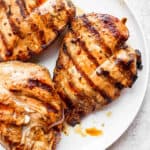 Plate of grilled chicken breasts that have marinated before grilling.