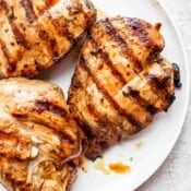 Plate of grilled chicken breasts that have marinated before grilling.