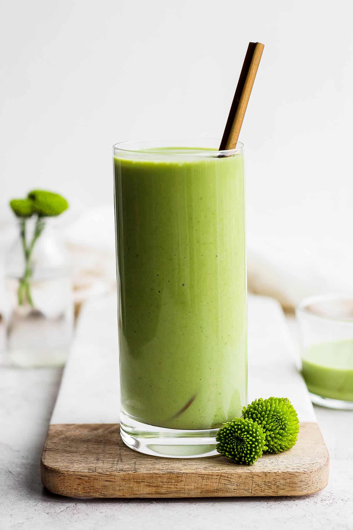 Green smoothie in a glass with a spoon in it.
