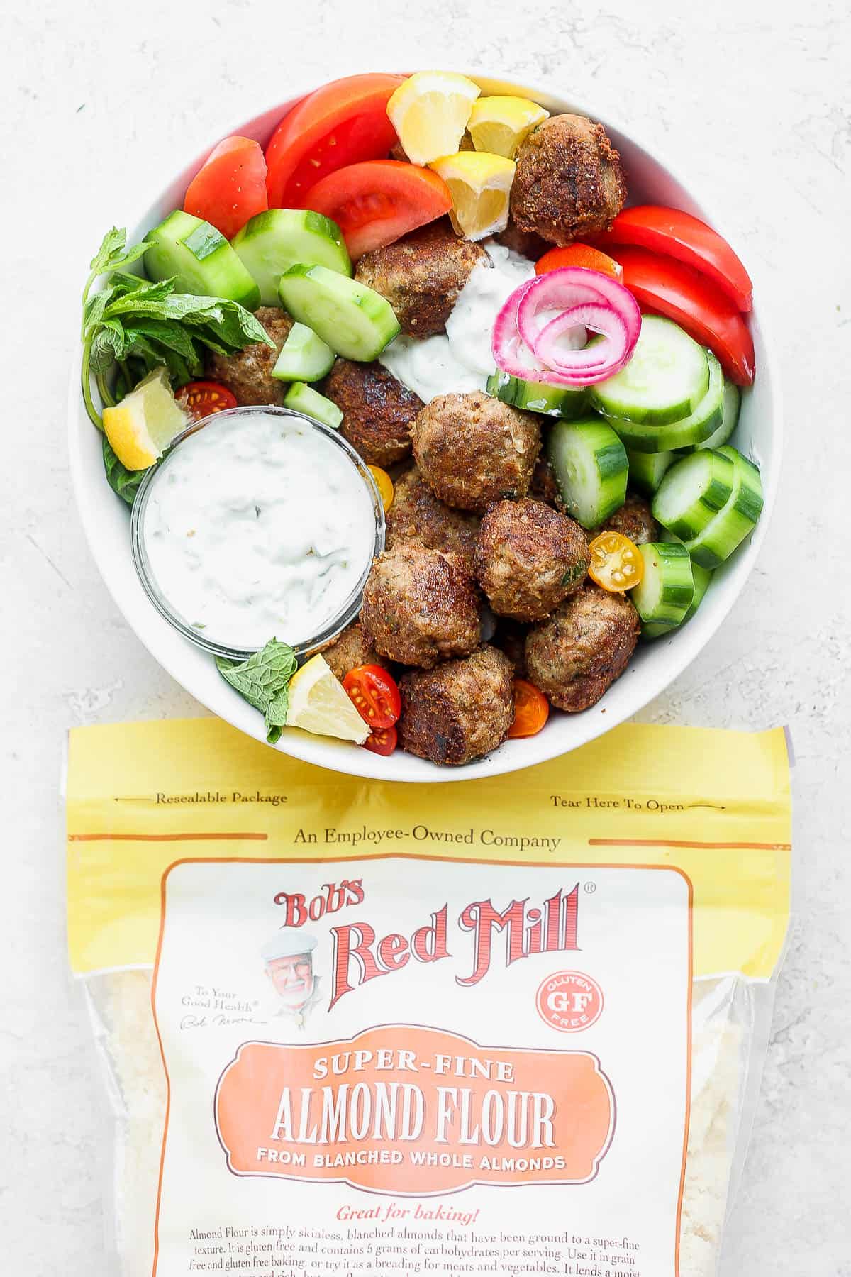 A gyro bowl next to a bag of Bob's Red Mill almond flour.