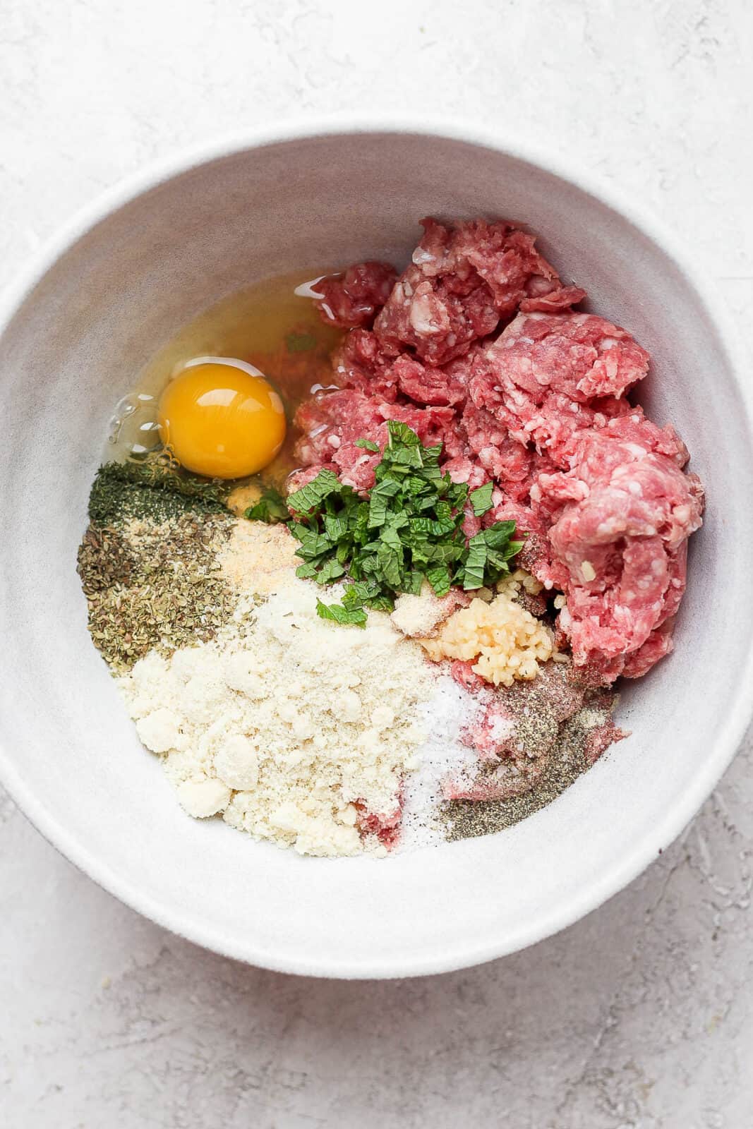 A bowl filed with lamb meatball ingredients.