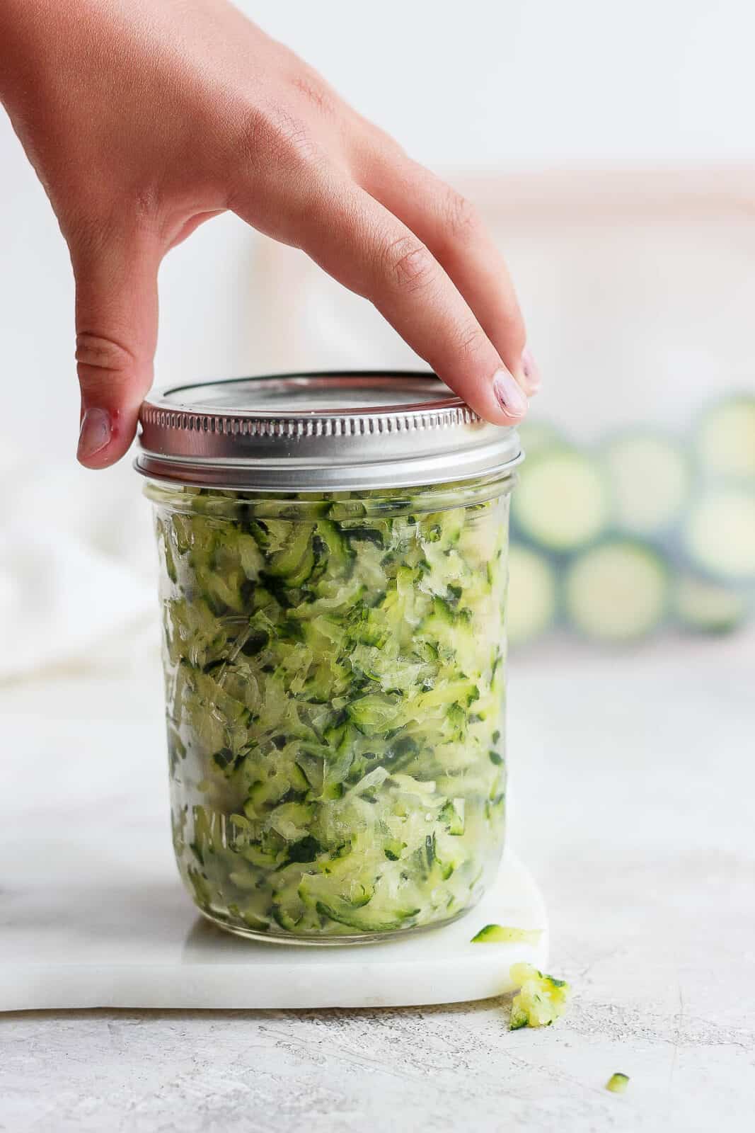 A mason jar of shredded zucchini.