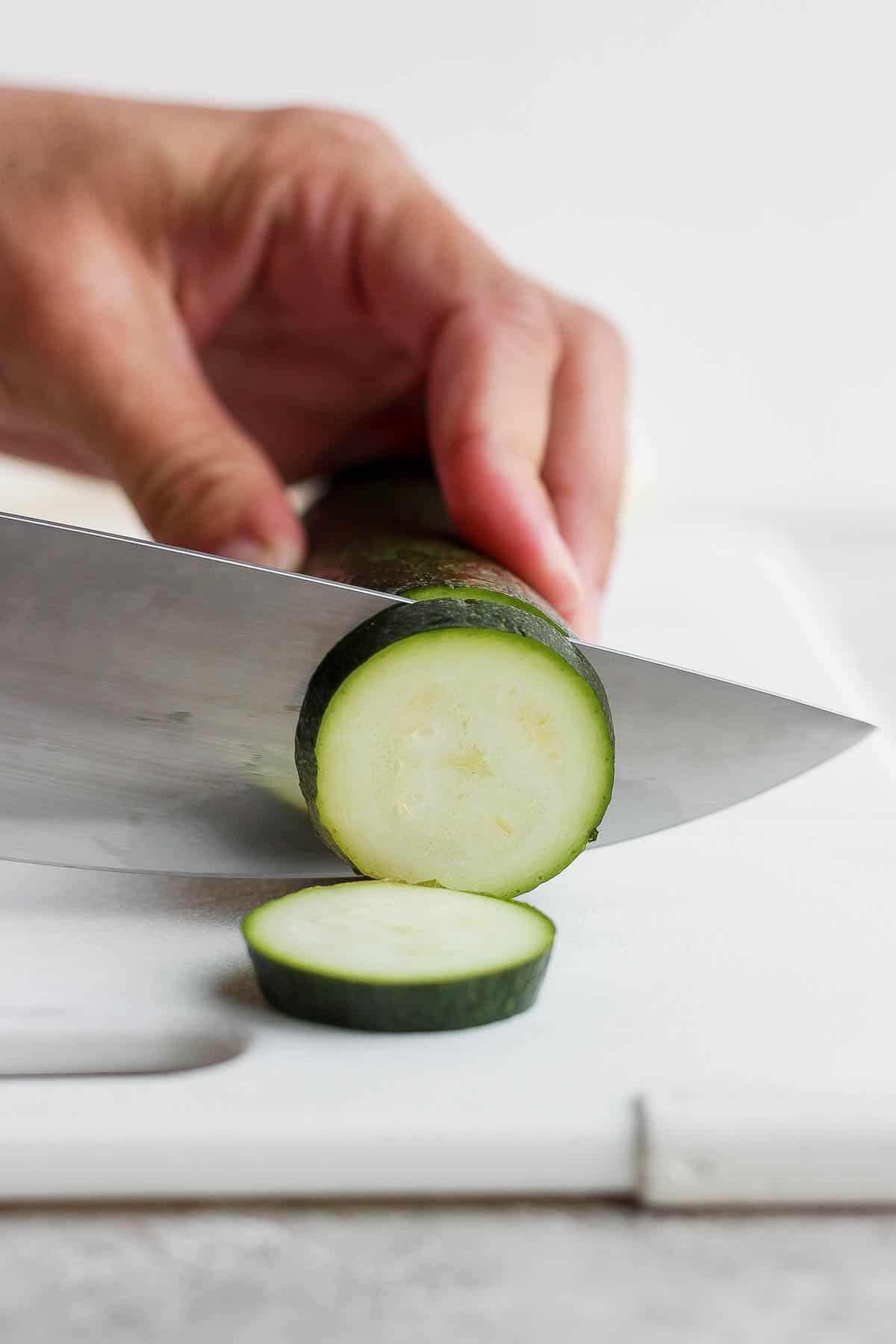 Someone slices a zucchini. 