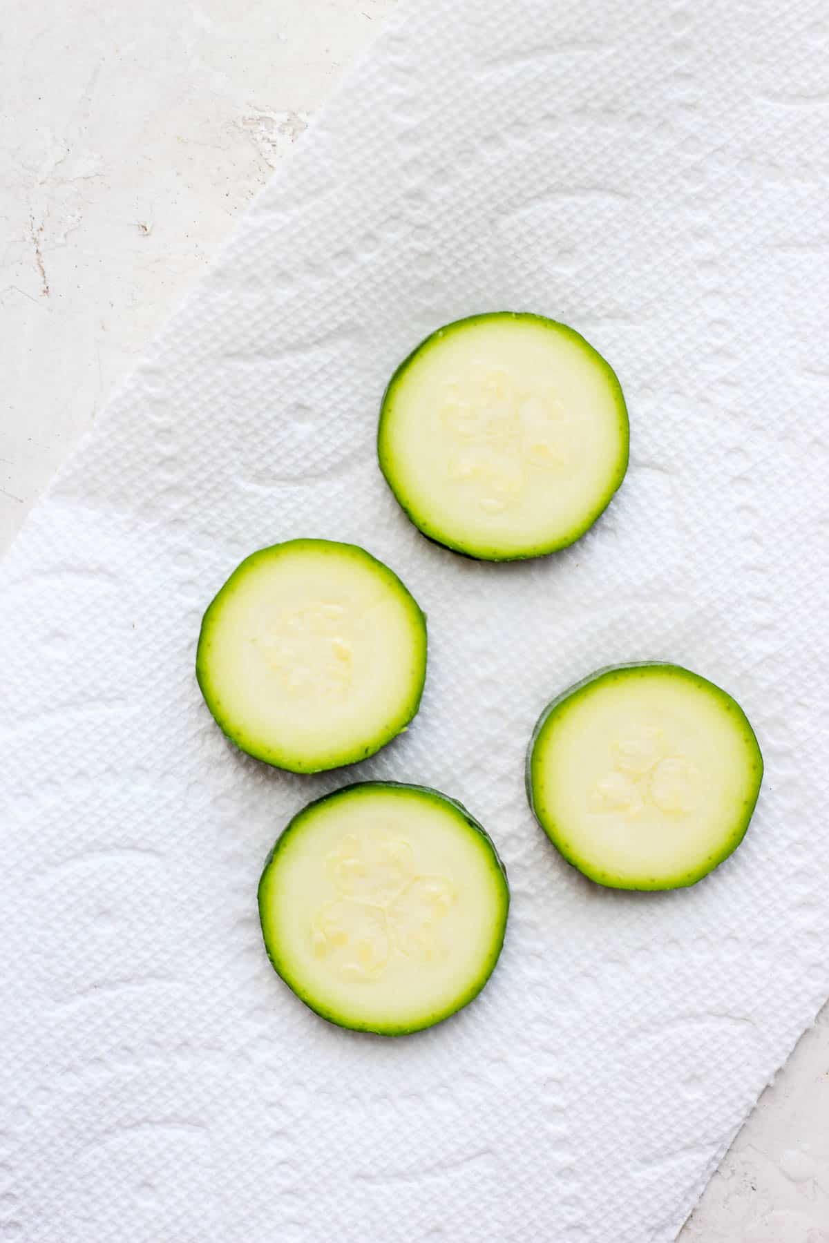 Zucchini slices on a piece of paper towel.
