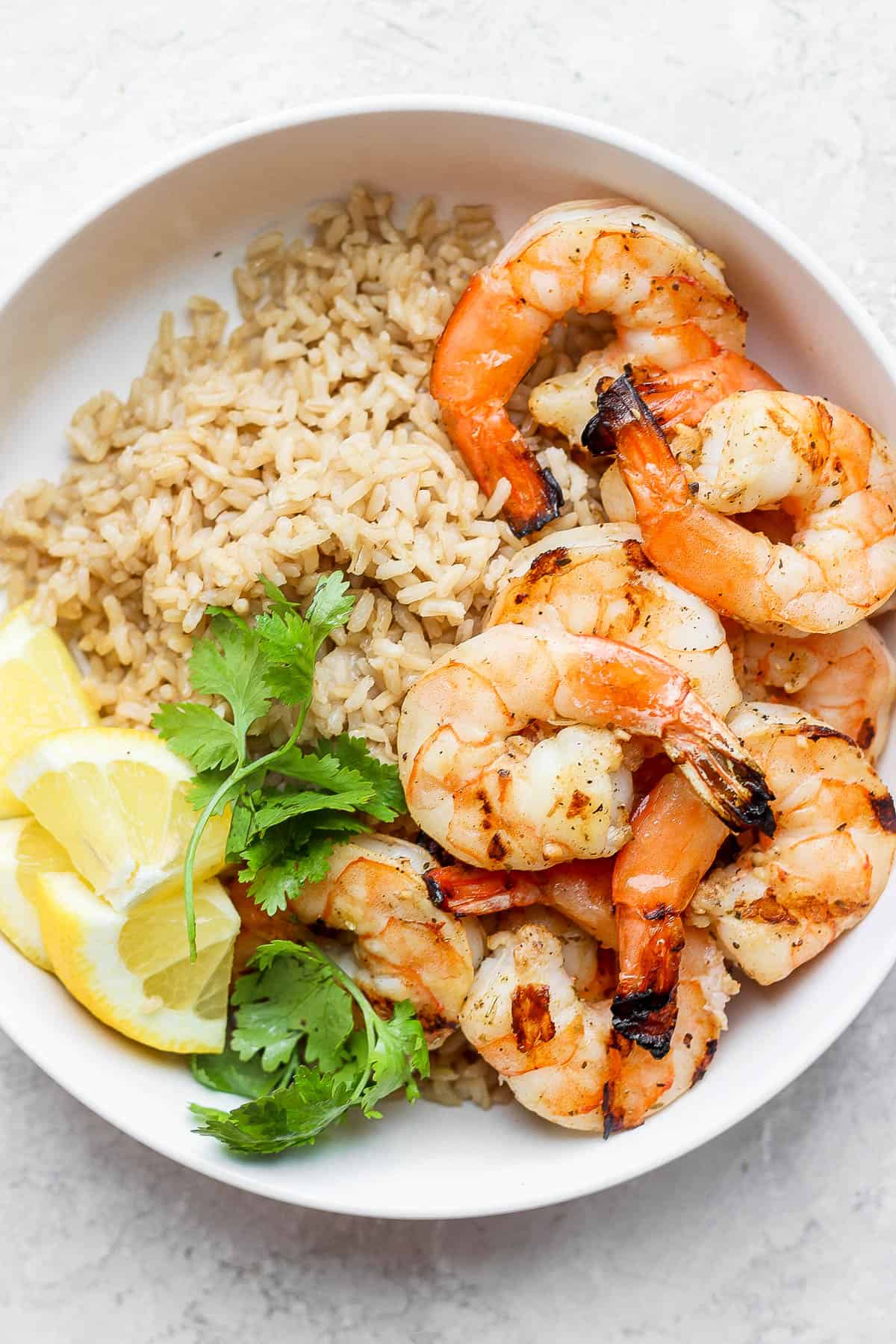 Grilled shrimp in a bowl with brown rice.