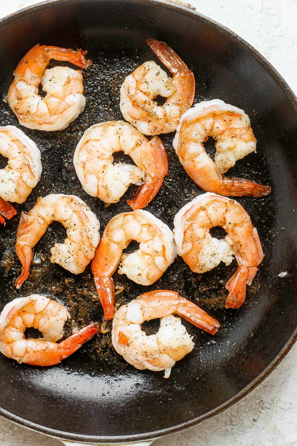 Pan fried shrimp in a cast iron pan.