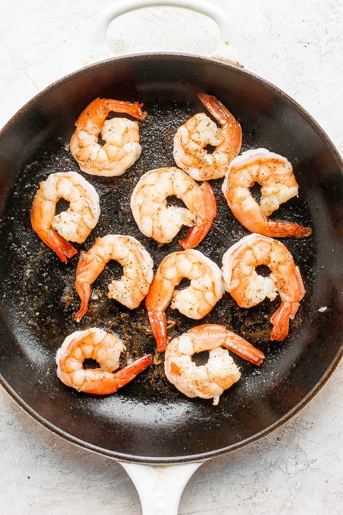 Pan fried shrimp in a cast iron pan.