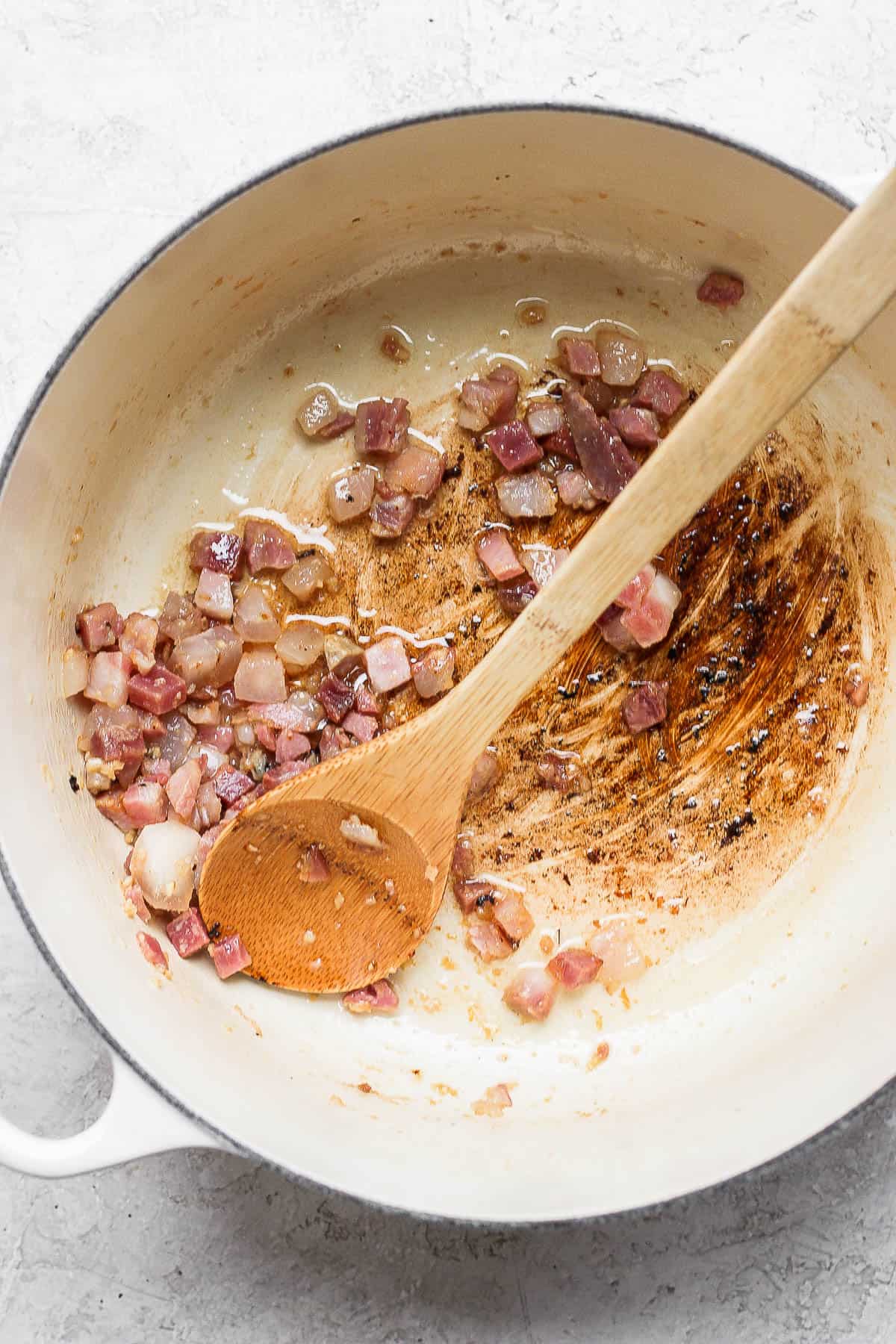 Dutch oven with rendered pancetta inside.