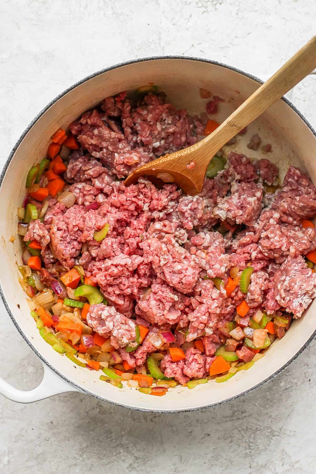 Dutch oven full of sautéed veggies and ground pork and beef.