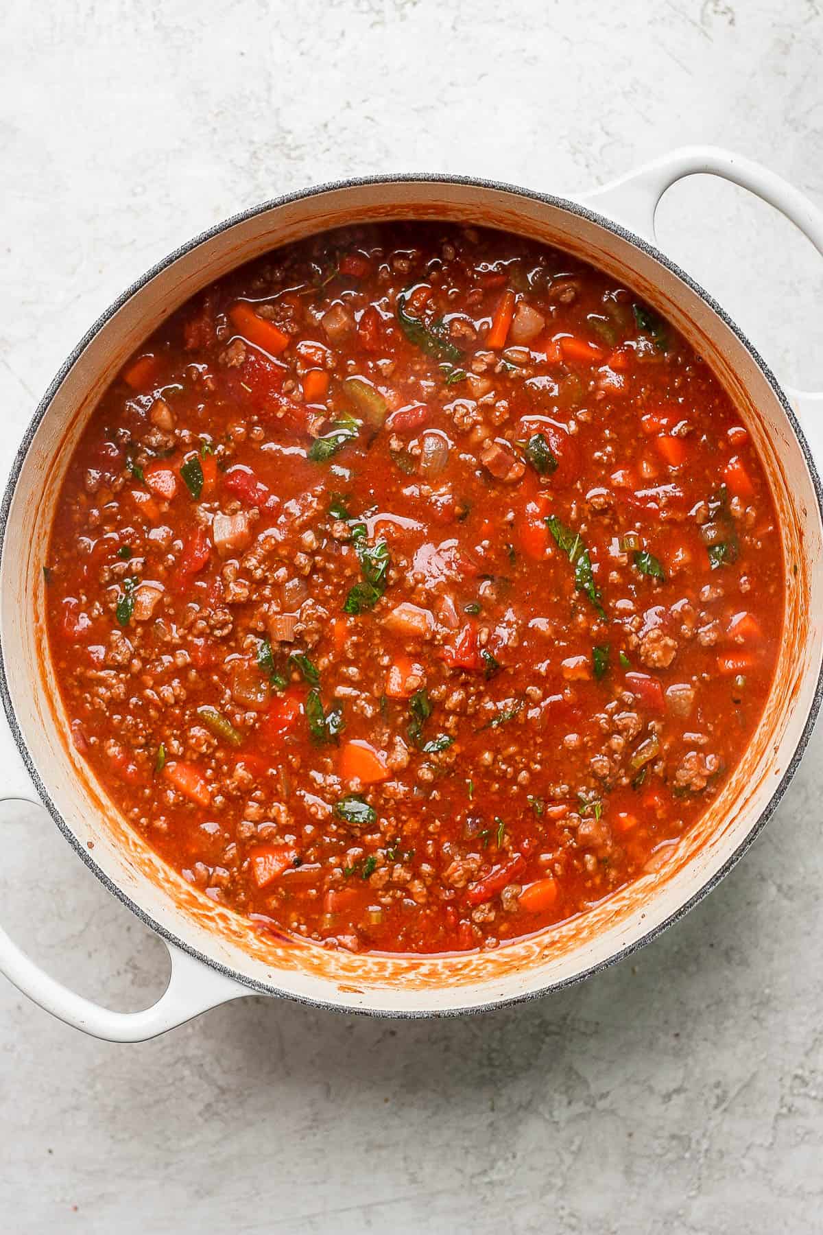 A dutch oven full of bolognese sauce.