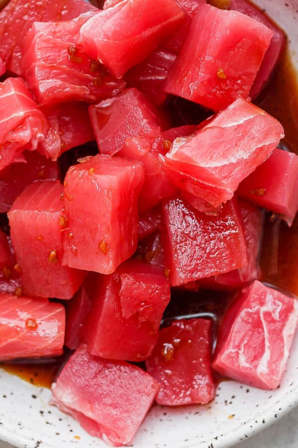 Pieces of raw tuna marinating in poke sauce.
