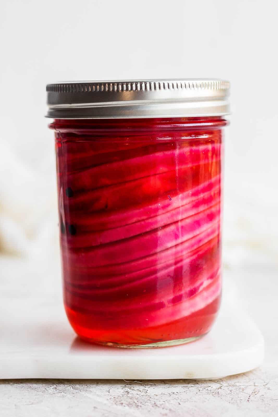 A mason jar of quick pickled red onions.