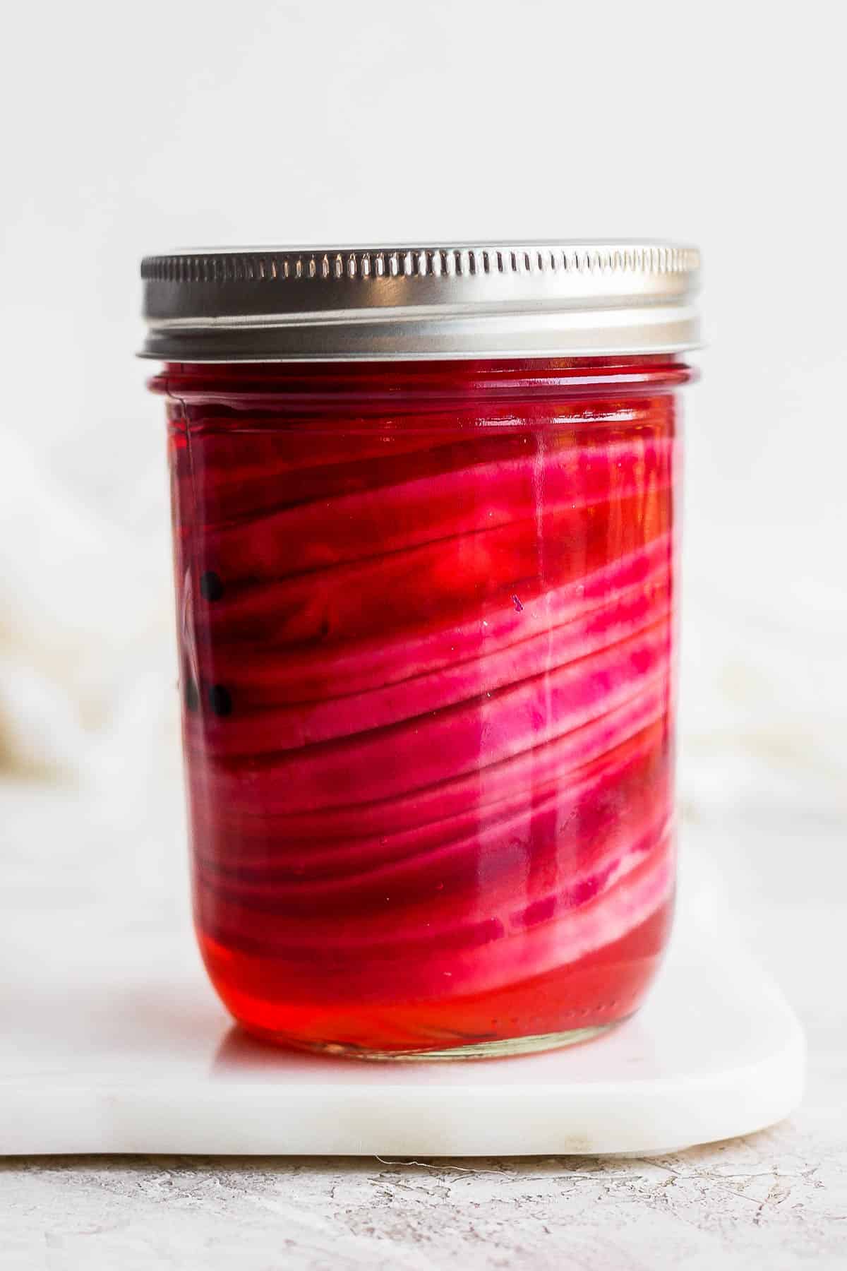 A mason jar of quick pickled red onions.