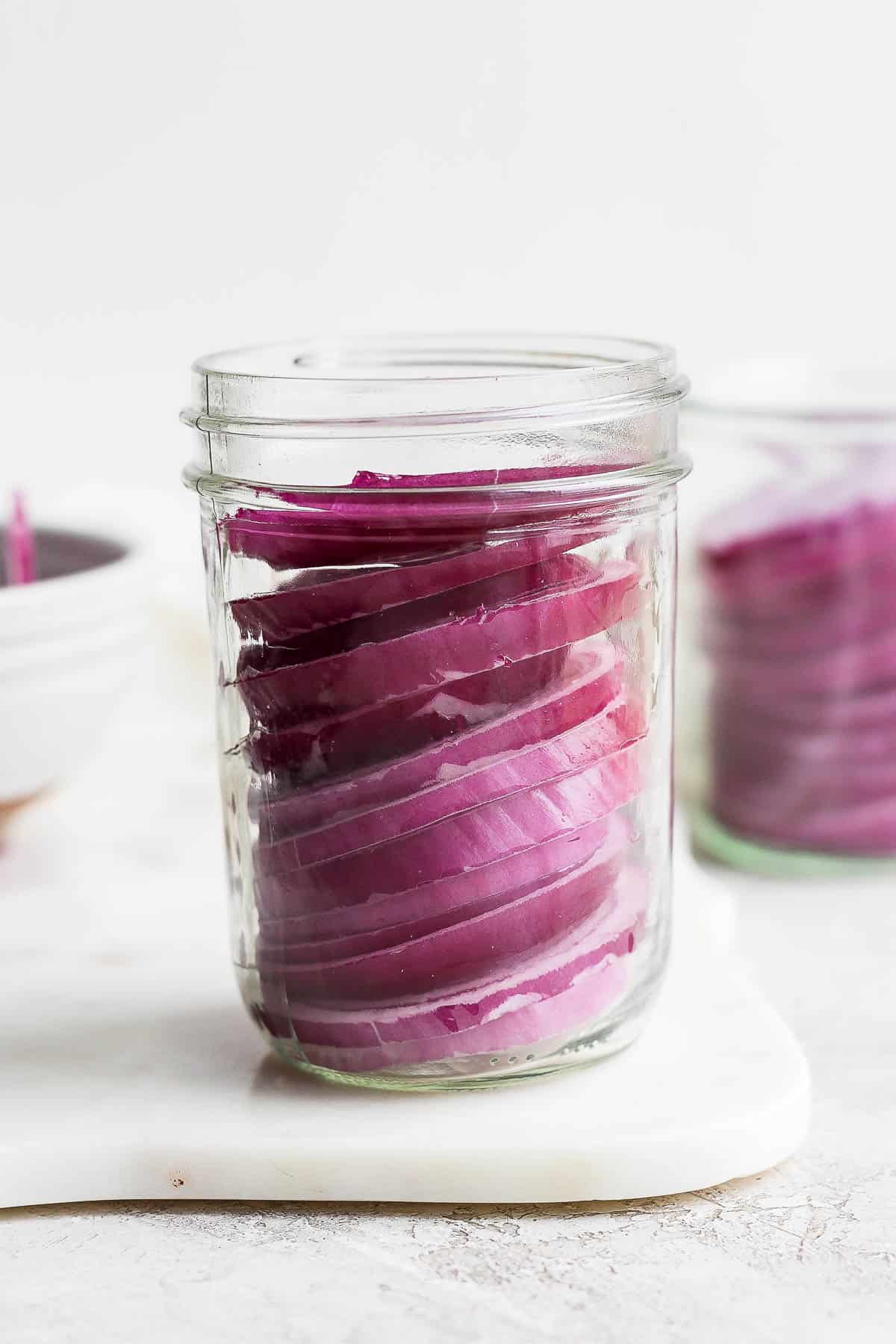 Slices of red onion in a jar.