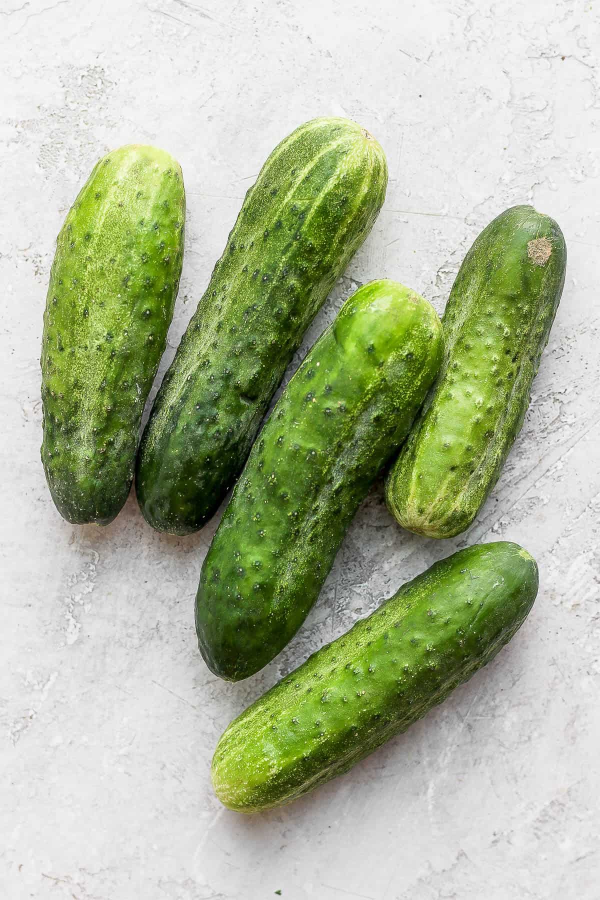Fresh pickling cucumbers on the counter.