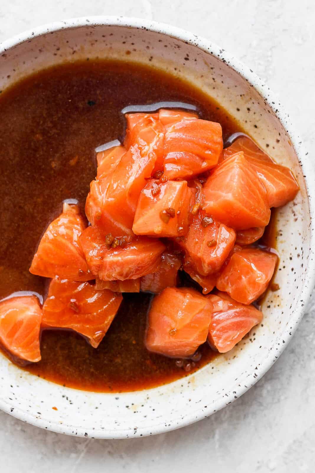 Poke sauce in a bowl with cut up salmon.