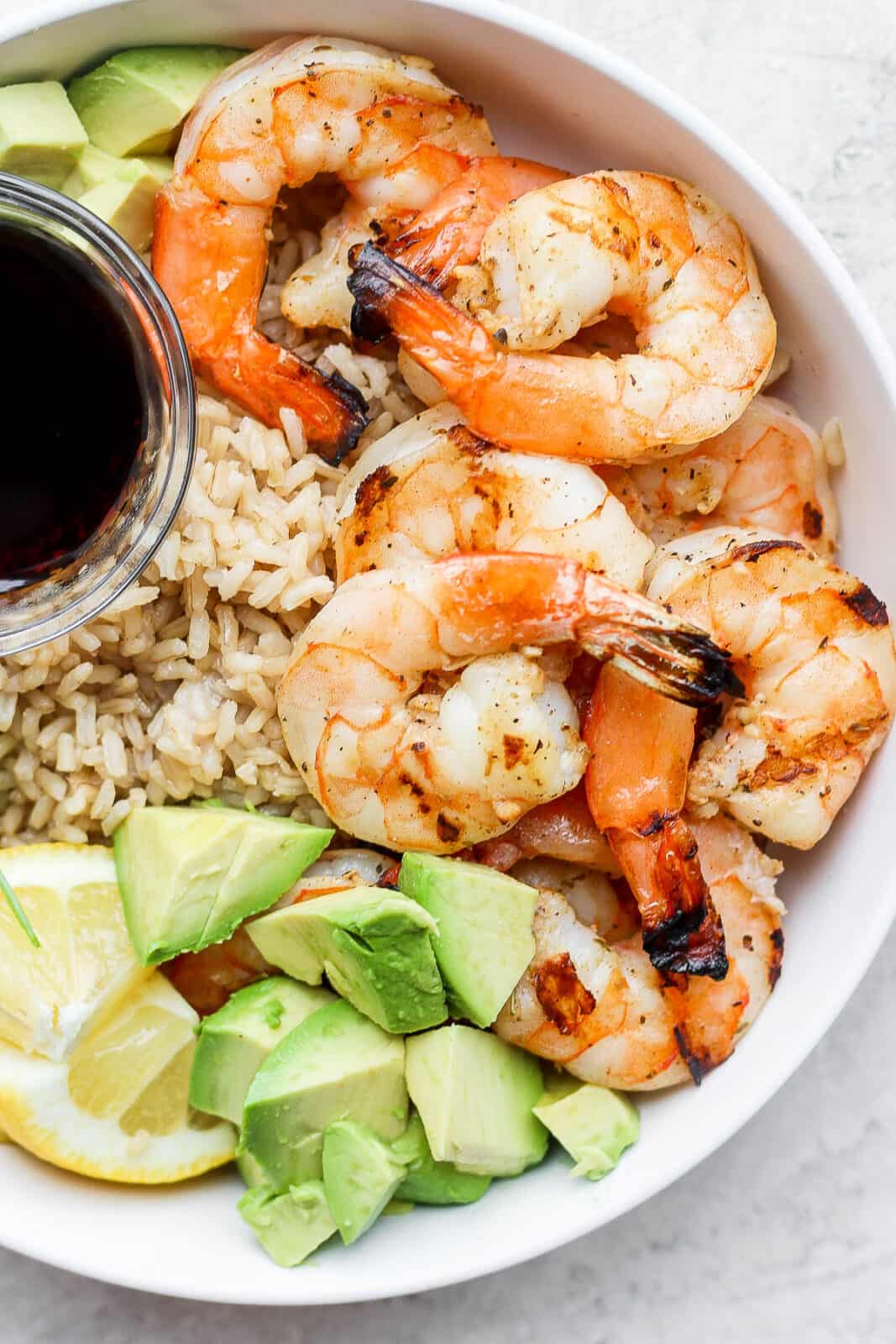 Shrimp rice bowl with a small dish of soy sauce.