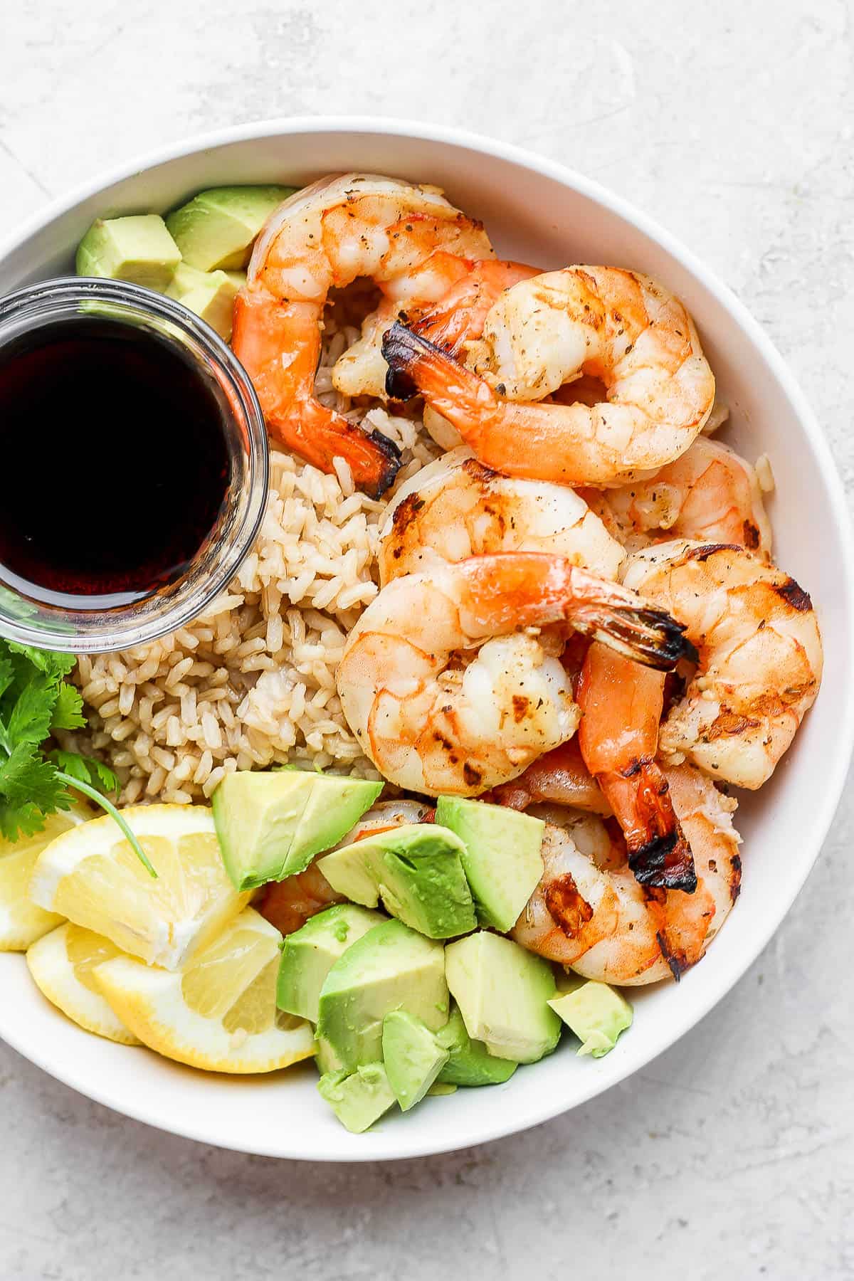 Shrimp rice bowl with a small dish of soy sauce.