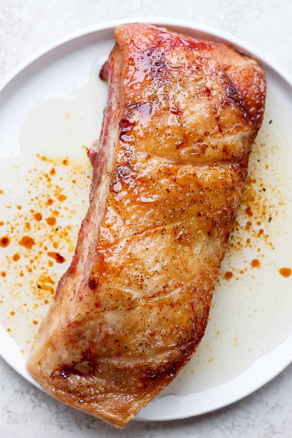 A piece of pork belly on a plate after smoking.