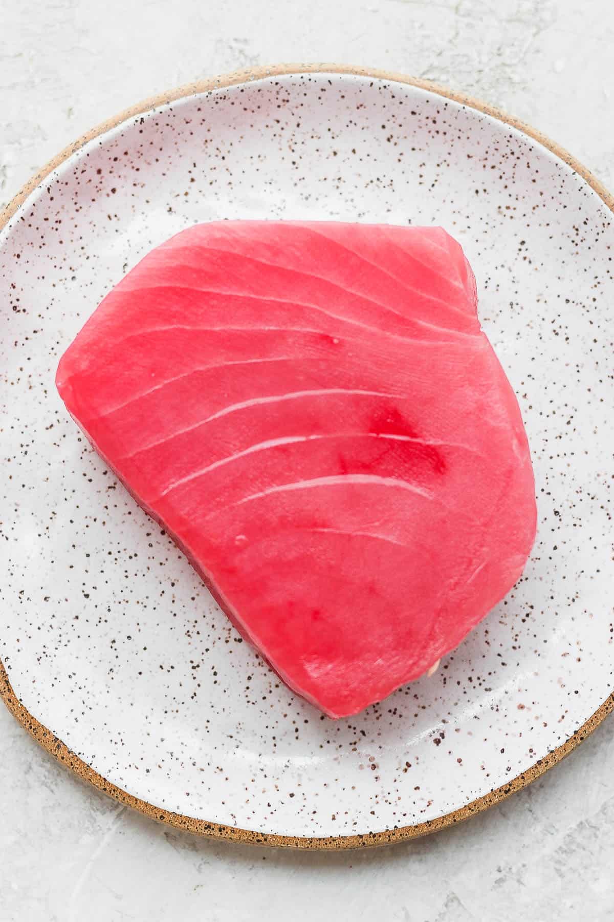 A raw tuna steak on a plate.