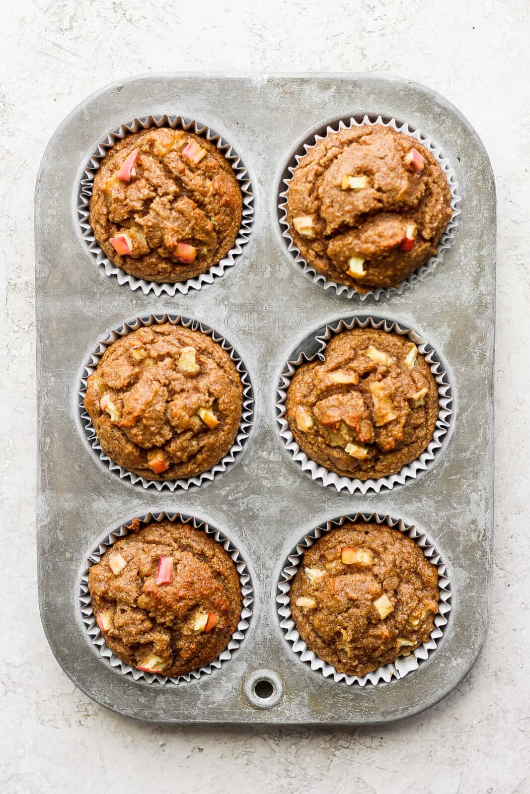 Apple cinnamon muffins in a muffin tin after baking.