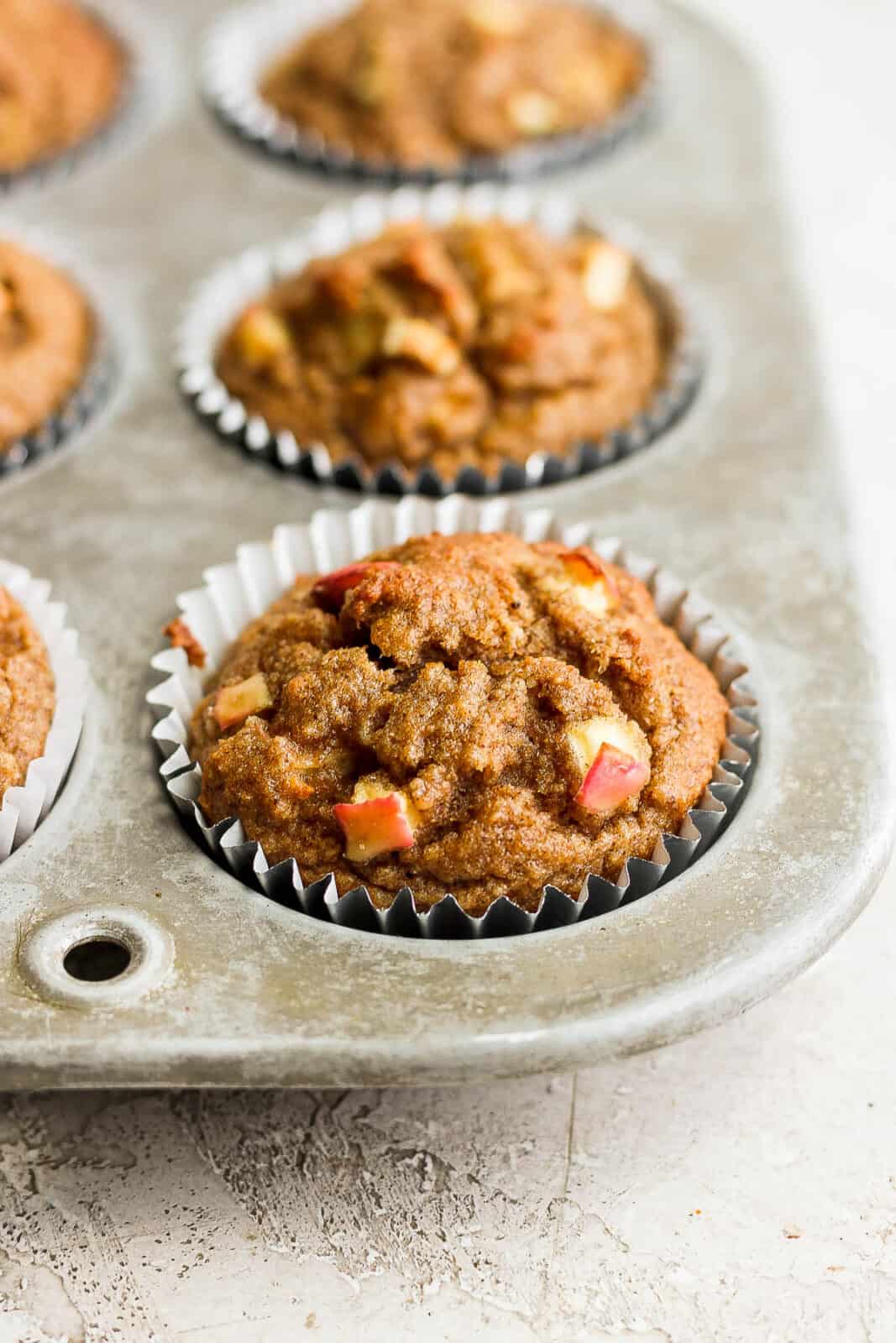 Apple cinnamon muffins in a muffin tin.