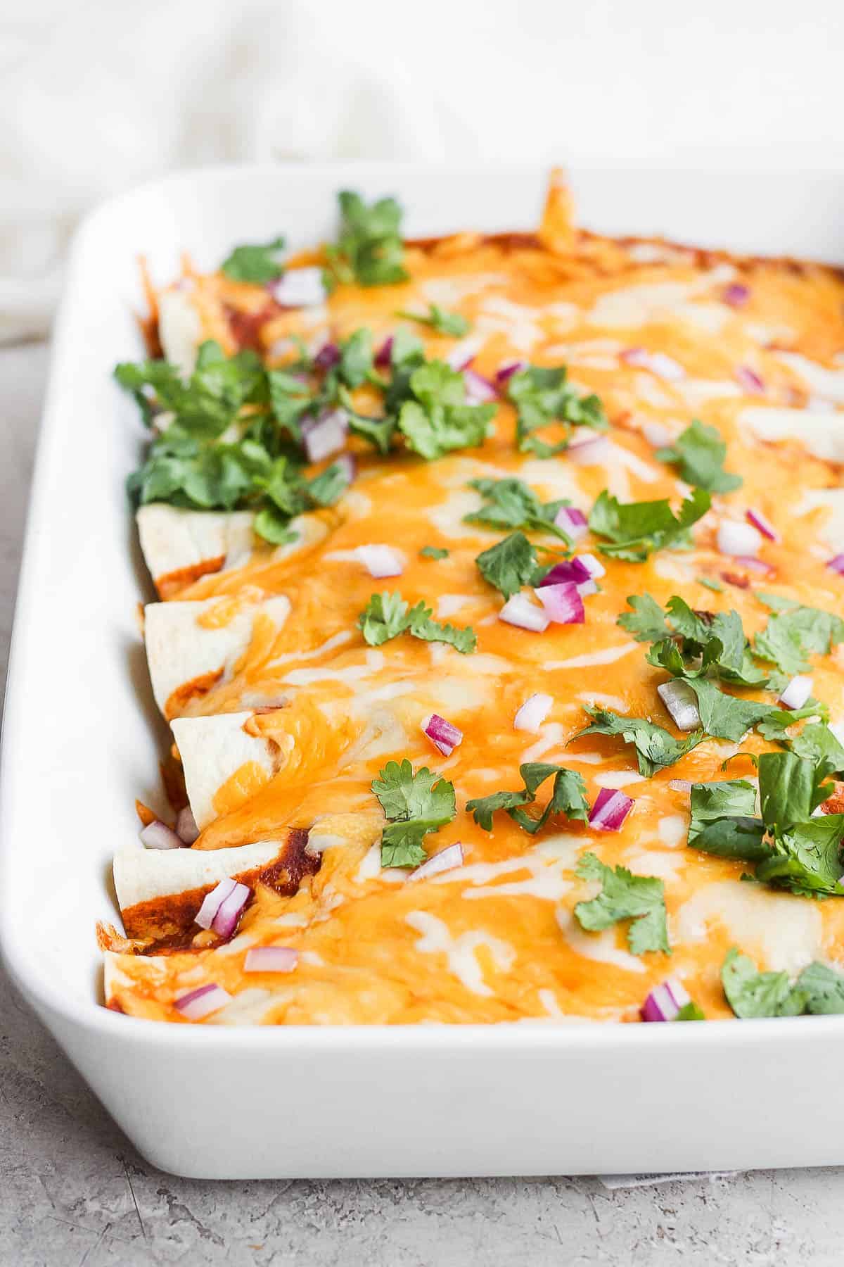 Side view of a pan of healthy chicken enchiladas.