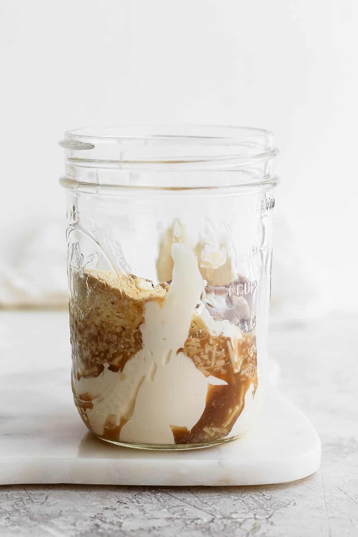 Healthy caesar dressing ingredients in a mason jar.